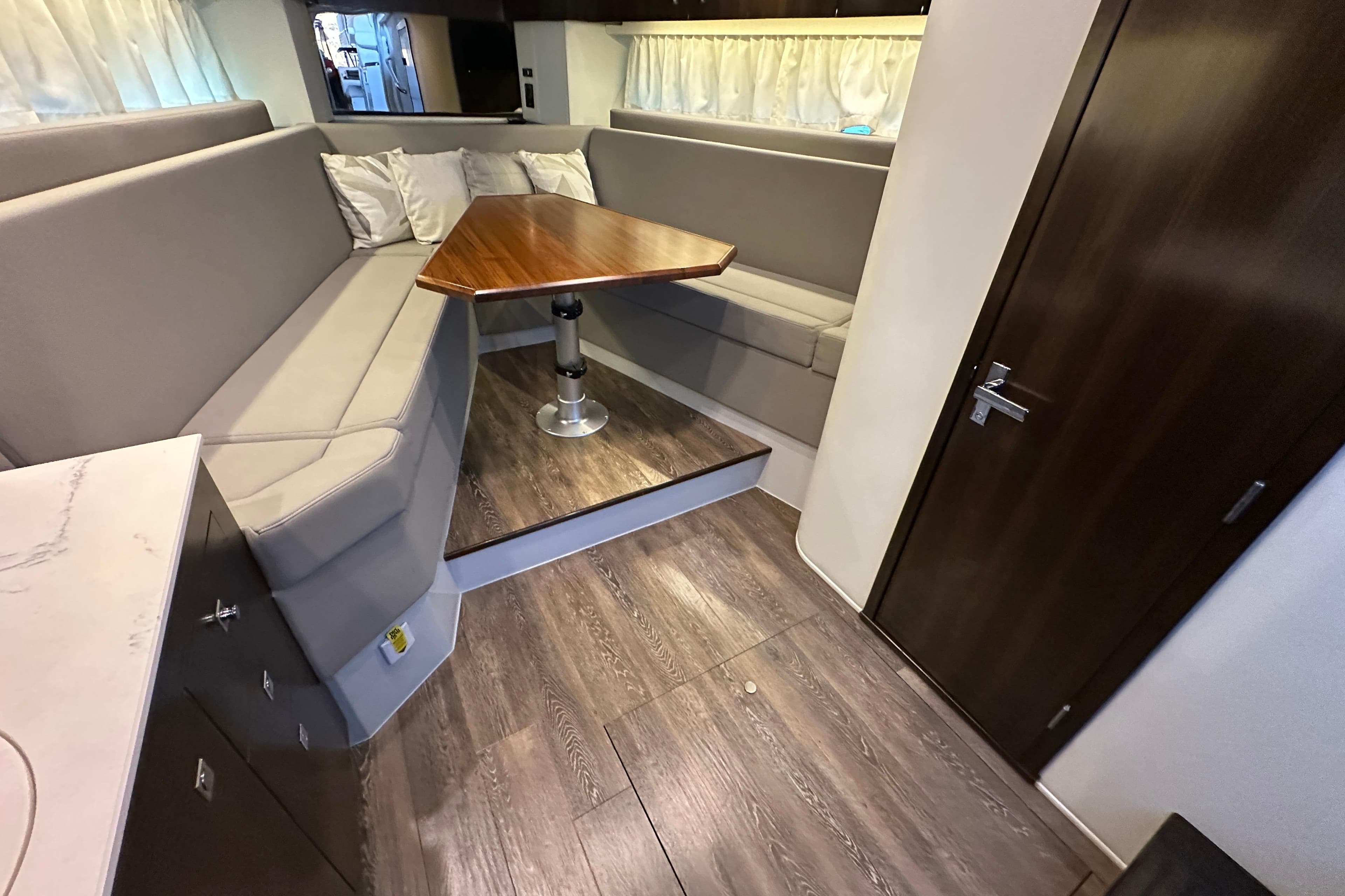 2021 Cruisers Yachts 390 Express Coupe interior with modern seating and wooden table.