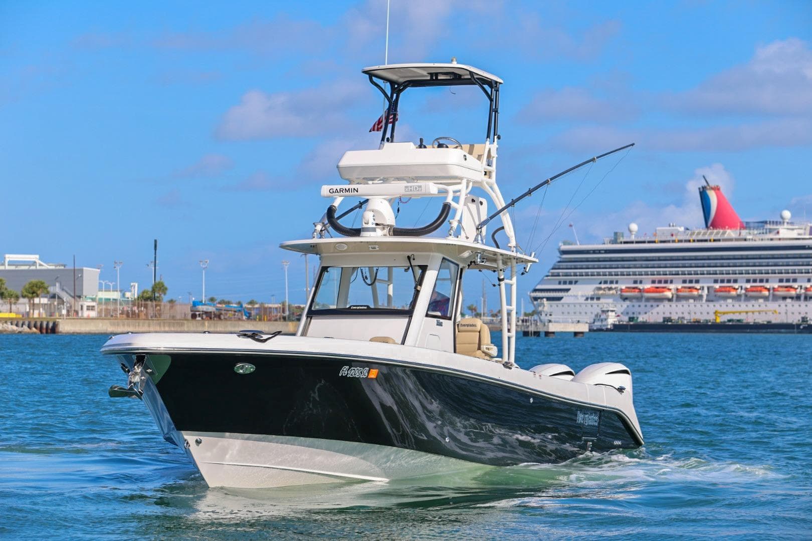 2017 Everglades 355 Center Console boat cruising near a large cruise ship in a harbor.