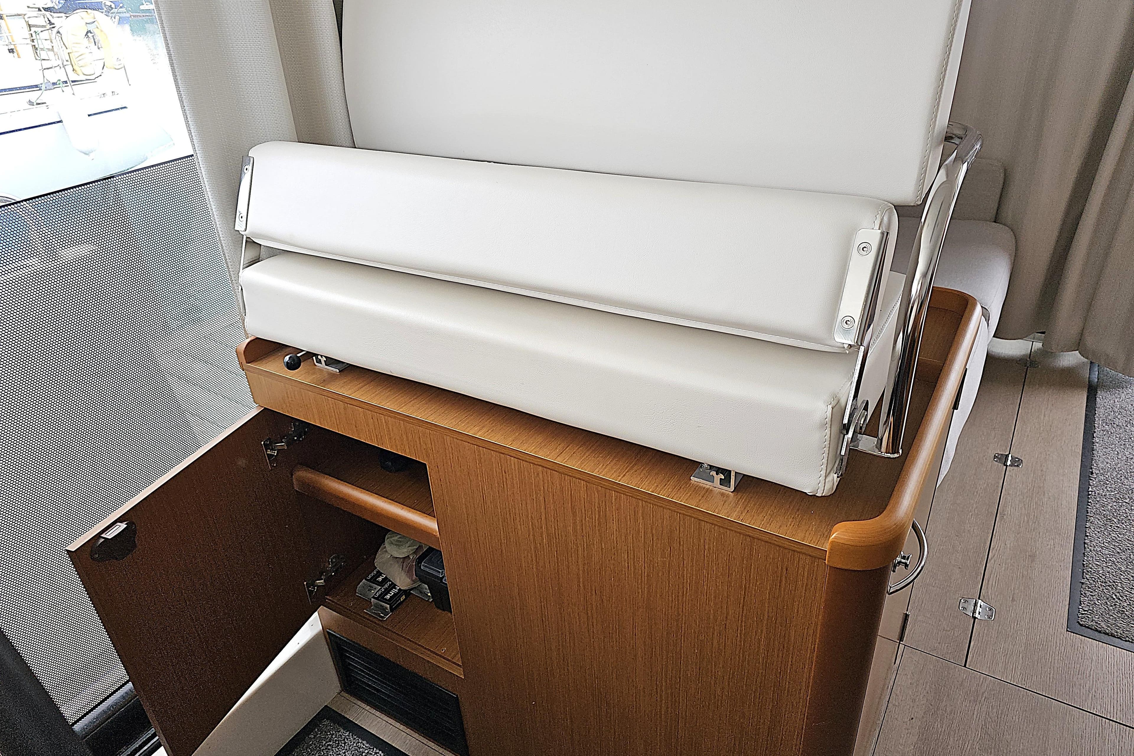 Interior of 2018 Beneteau Swift Trawler 35 with white seating and wooden cabinetry.