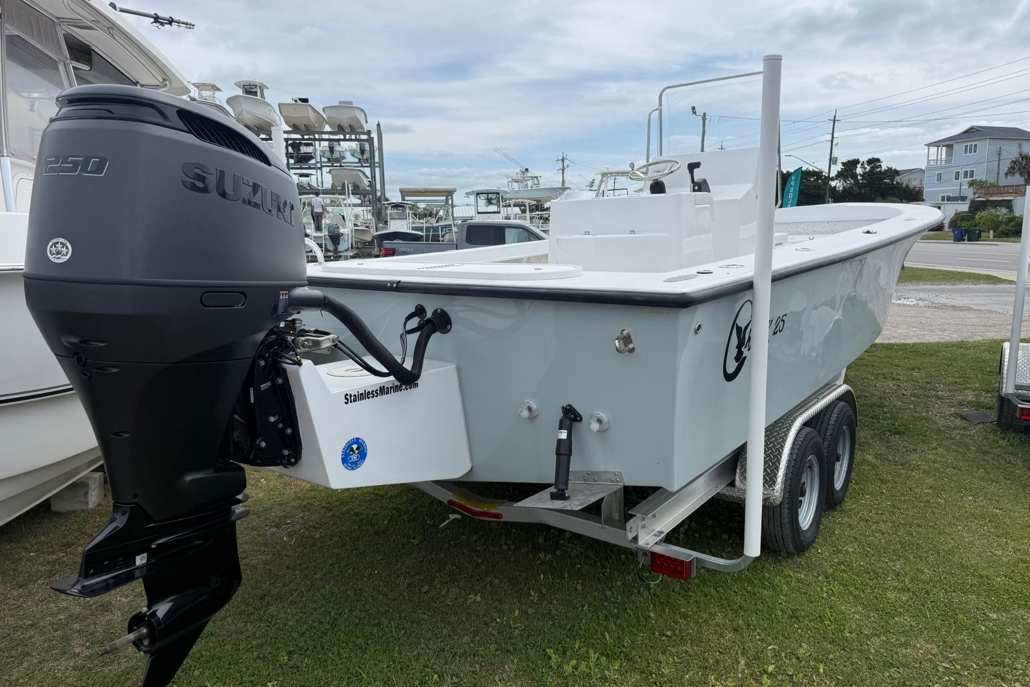 2026 C-Hawk 25 Center Console boat with Suzuki engine on trailer, parked outdoors.