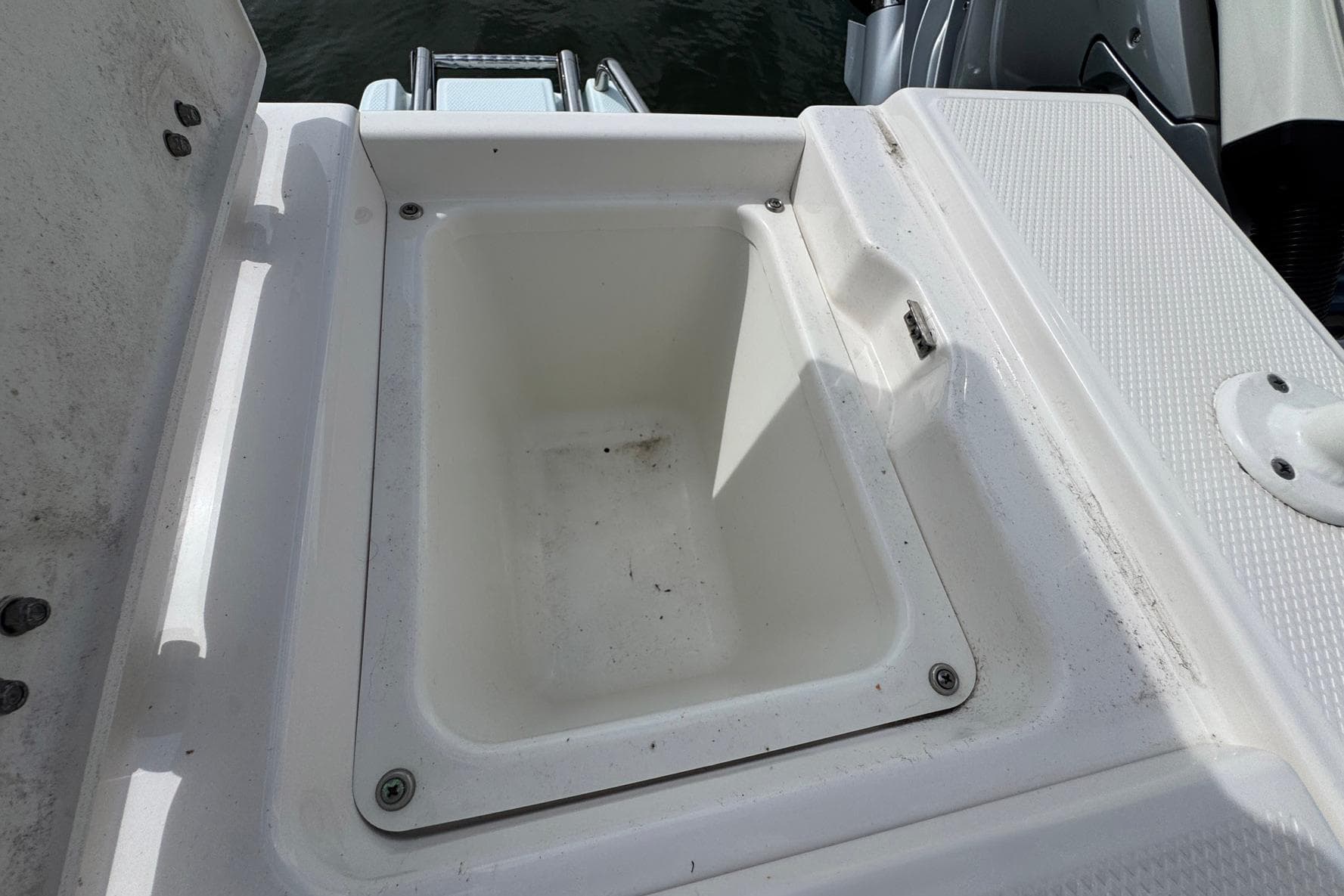 2021 Robalo 246 Cayman boat storage compartment, open and empty, with visible hardware.
