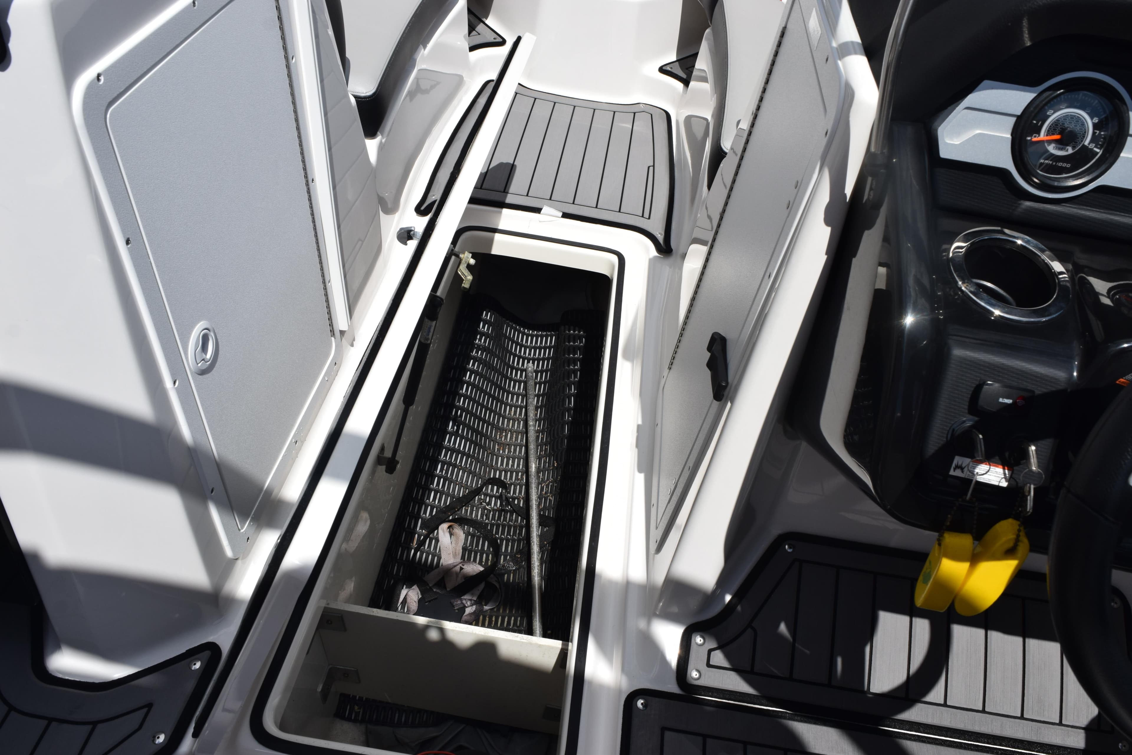 2018 Yamaha Boats 212X interior storage compartment with open hatch and dashboard view.