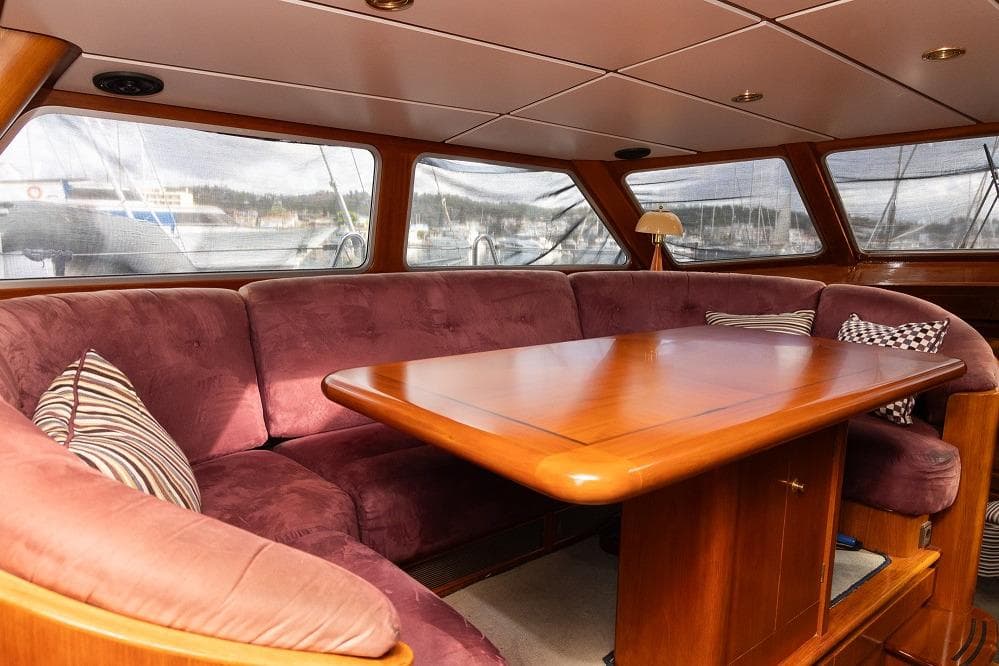 Luxurious interior of a 1996 Jongert 30M yacht with plush seating and wooden table.