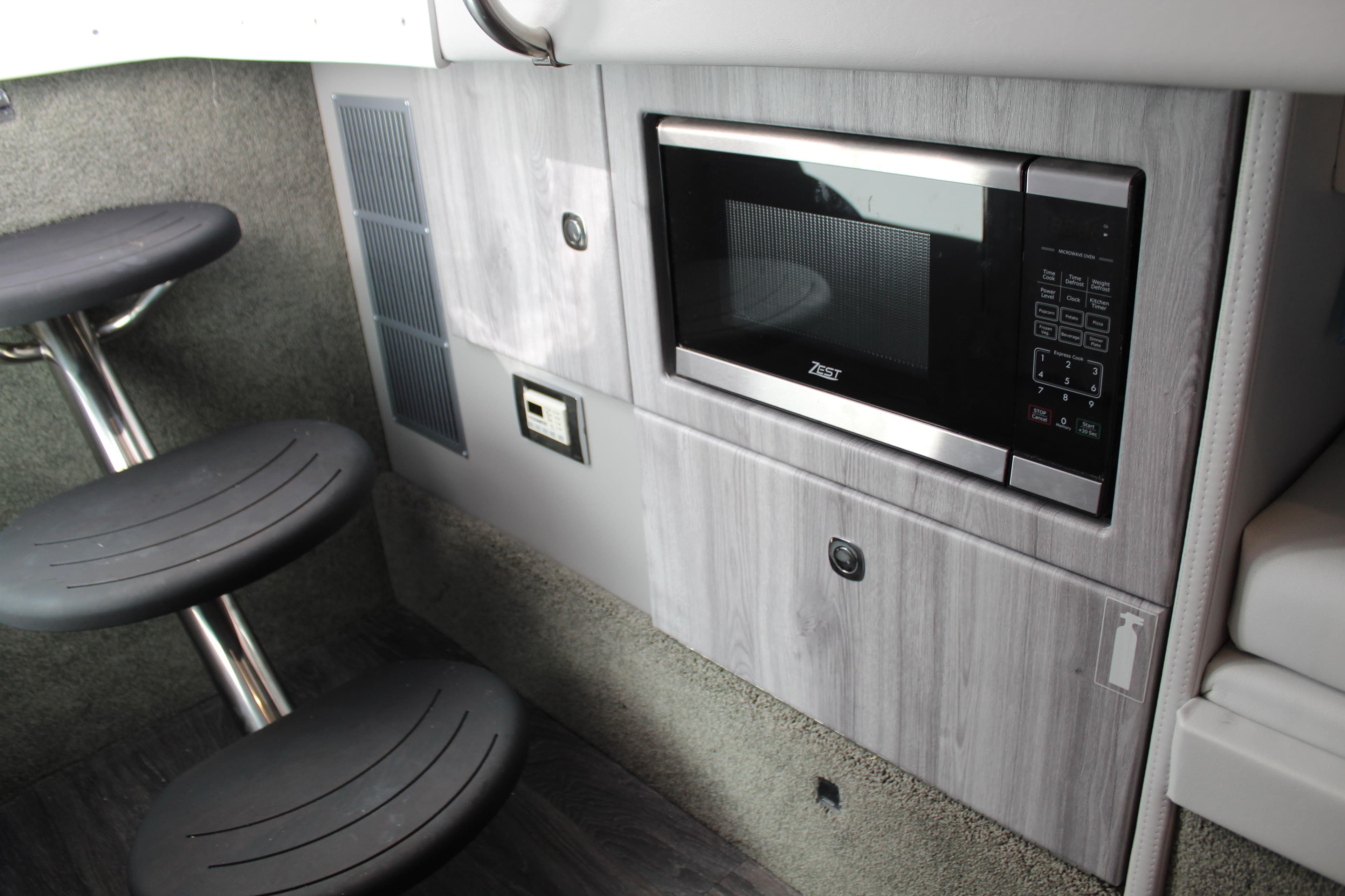 2023 Formula 330 Crossover Bowrider interior with microwave and seating area.