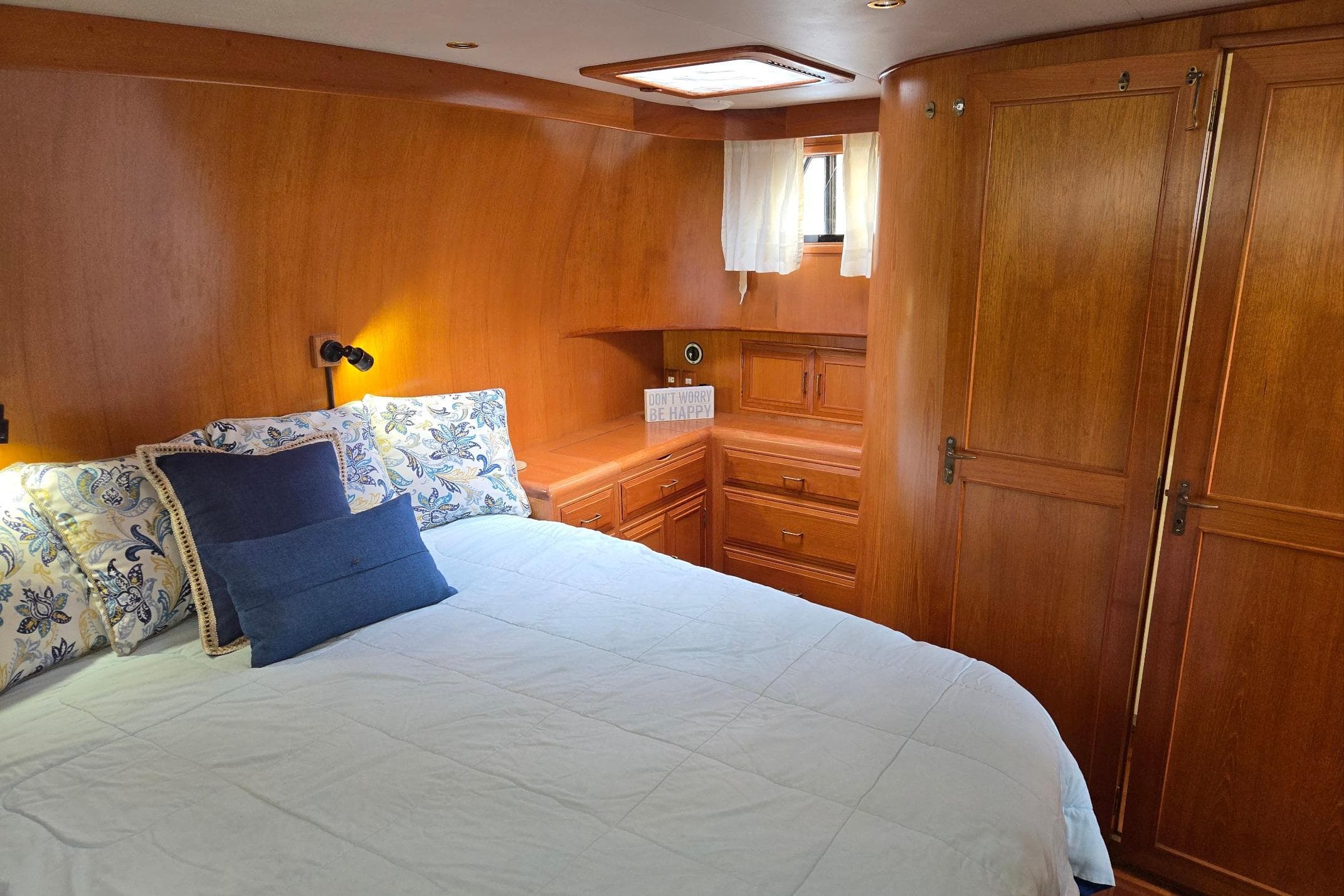 Cozy bedroom in 1993 Ocean Alexander 423 Classicco yacht with wooden interior and plush bedding.