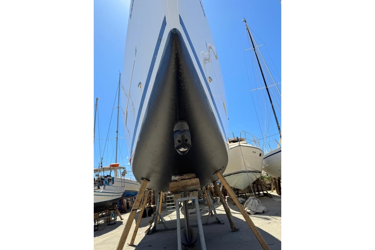 2018 Dufour 412 sailboat on dry dock, viewed from the bow under a clear blue sky.