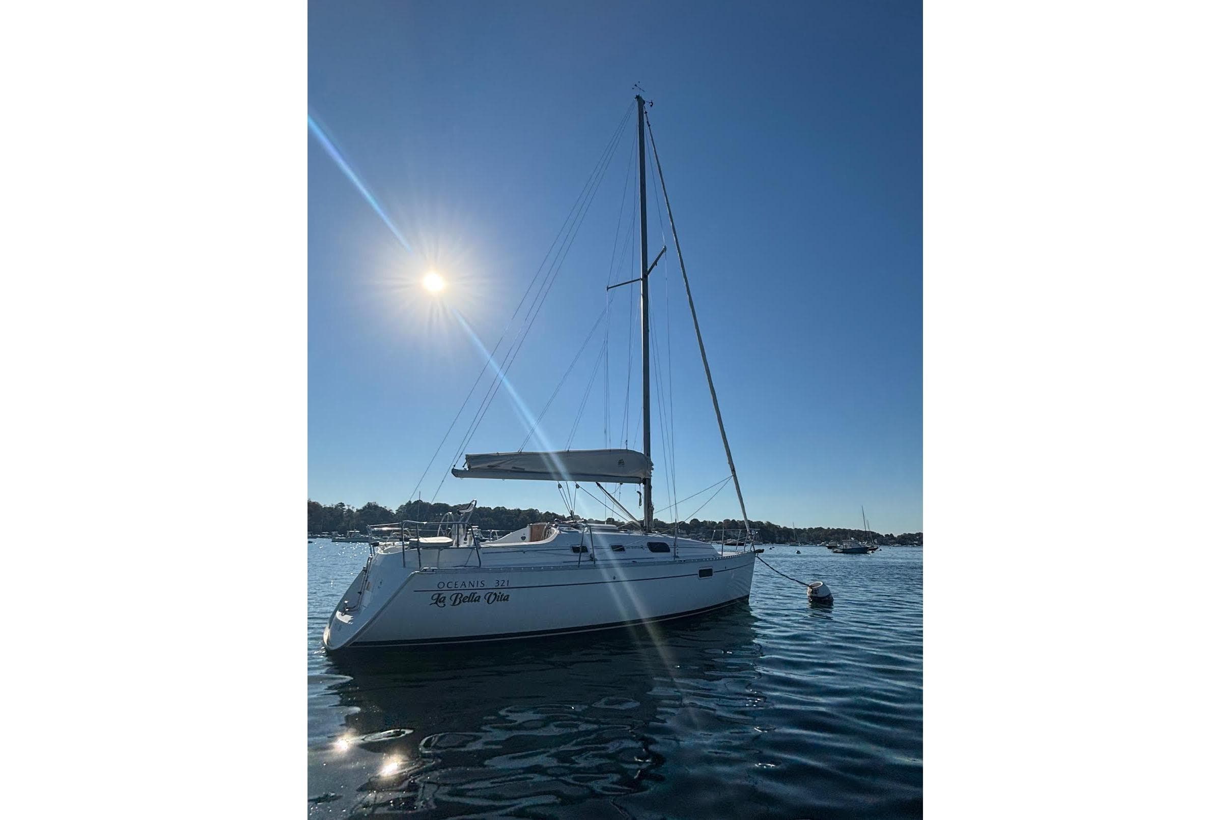 1999 Beneteau Oceanis 321 sailboat on calm water under bright sun.