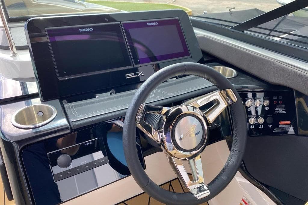 2024 Sea Ray SLX 260 helm with dual Simrad displays and modern steering wheel.