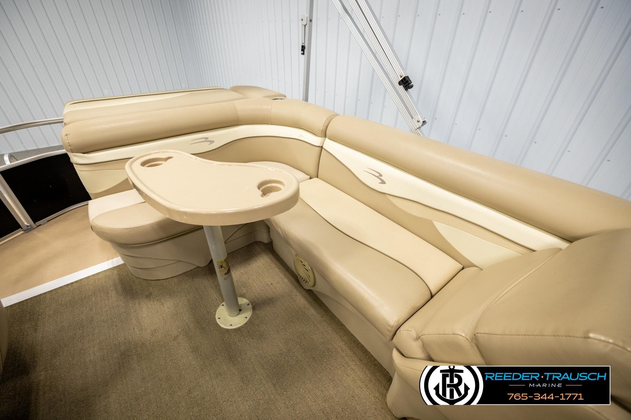 2013 Bennington 20 SLMX pontoon boat interior with beige seating and table.