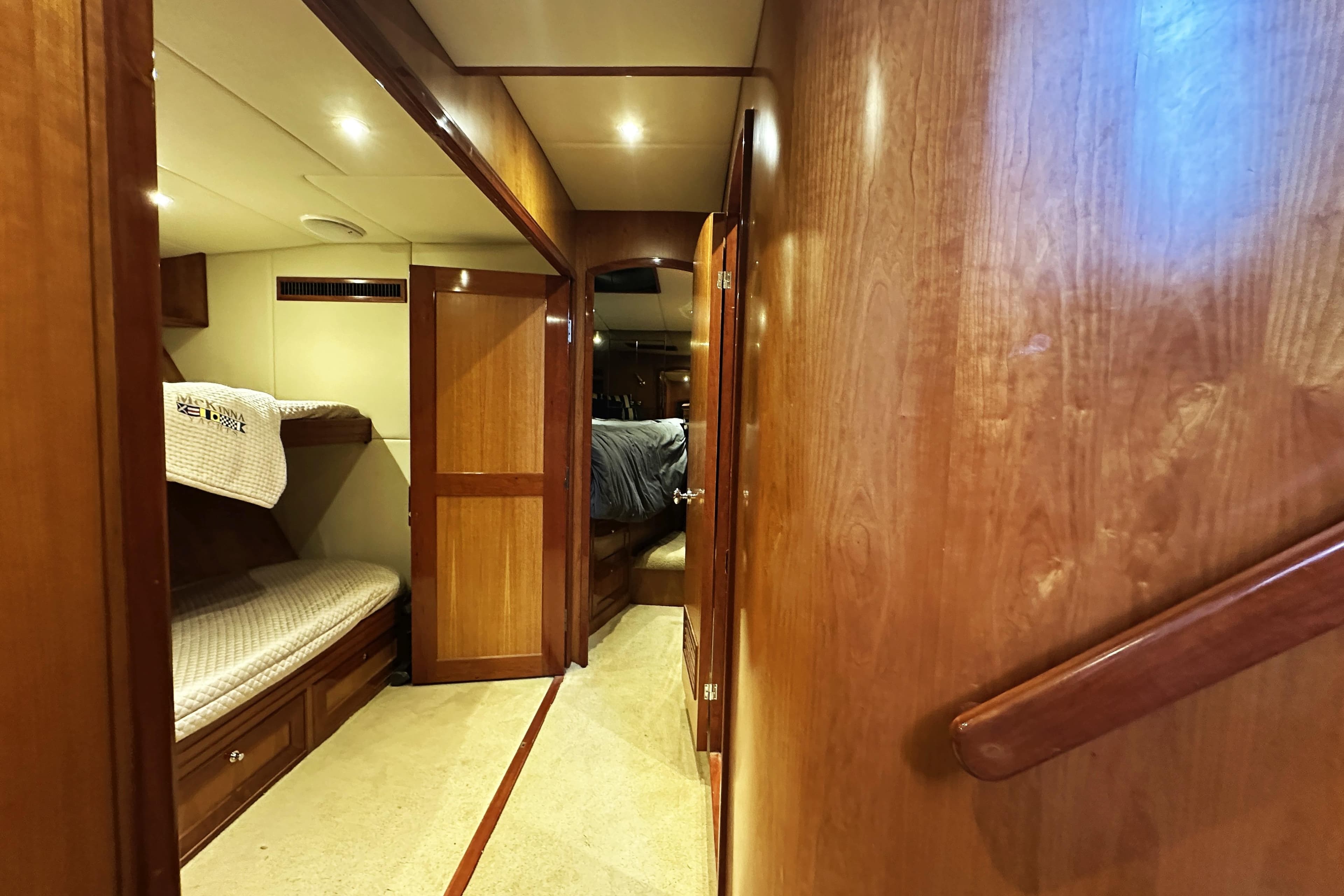 Interior of 2004 McKinna 57 PHMY yacht with wooden finishes and cozy sleeping area.