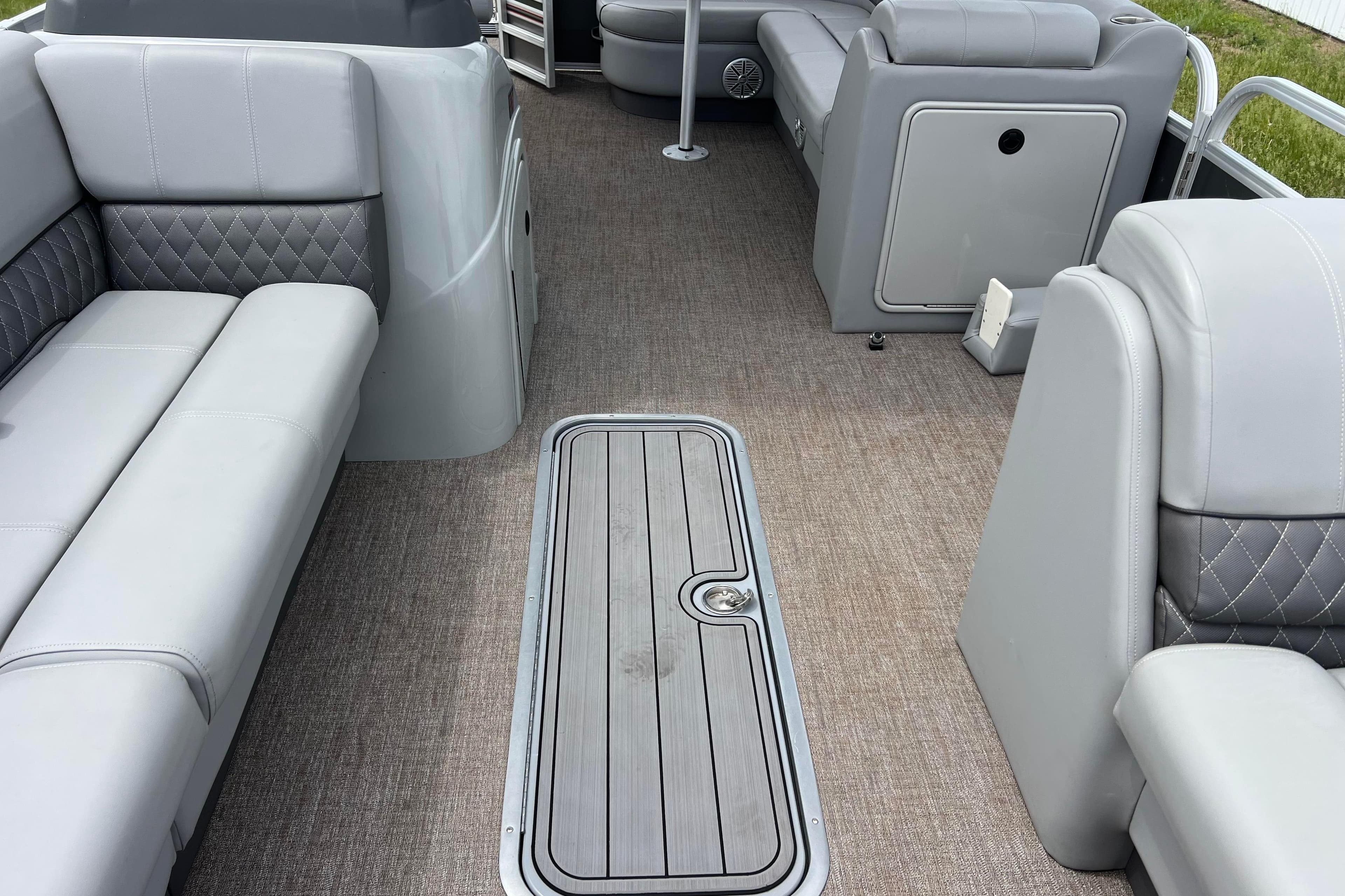 2023 Ranger Reata 223C boat interior with gray seating and carpeted flooring.