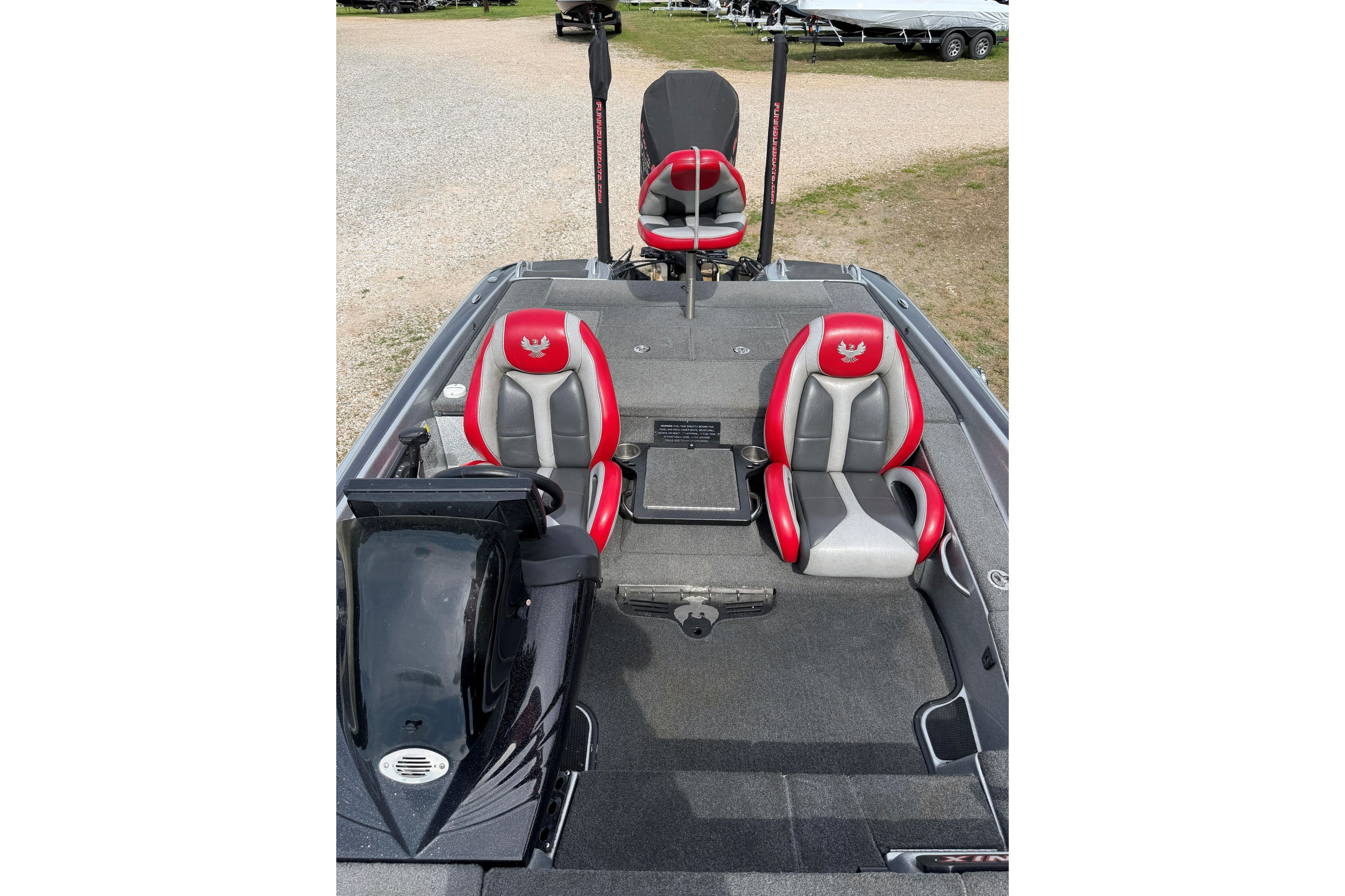 2019 Phoenix 920 ProXP boat interior with red and gray seats, parked outdoors.