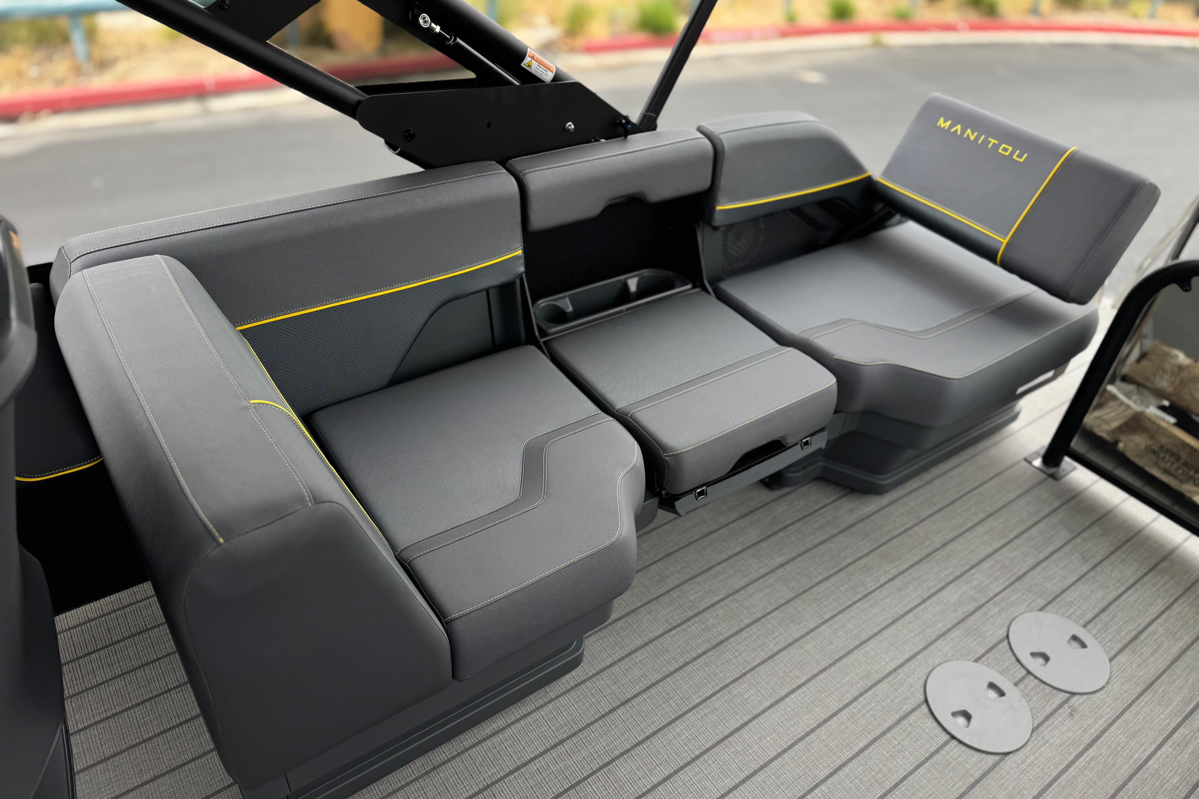 2025 Manitou EXPLORE 24 boat interior with sleek gray seating and yellow accents.