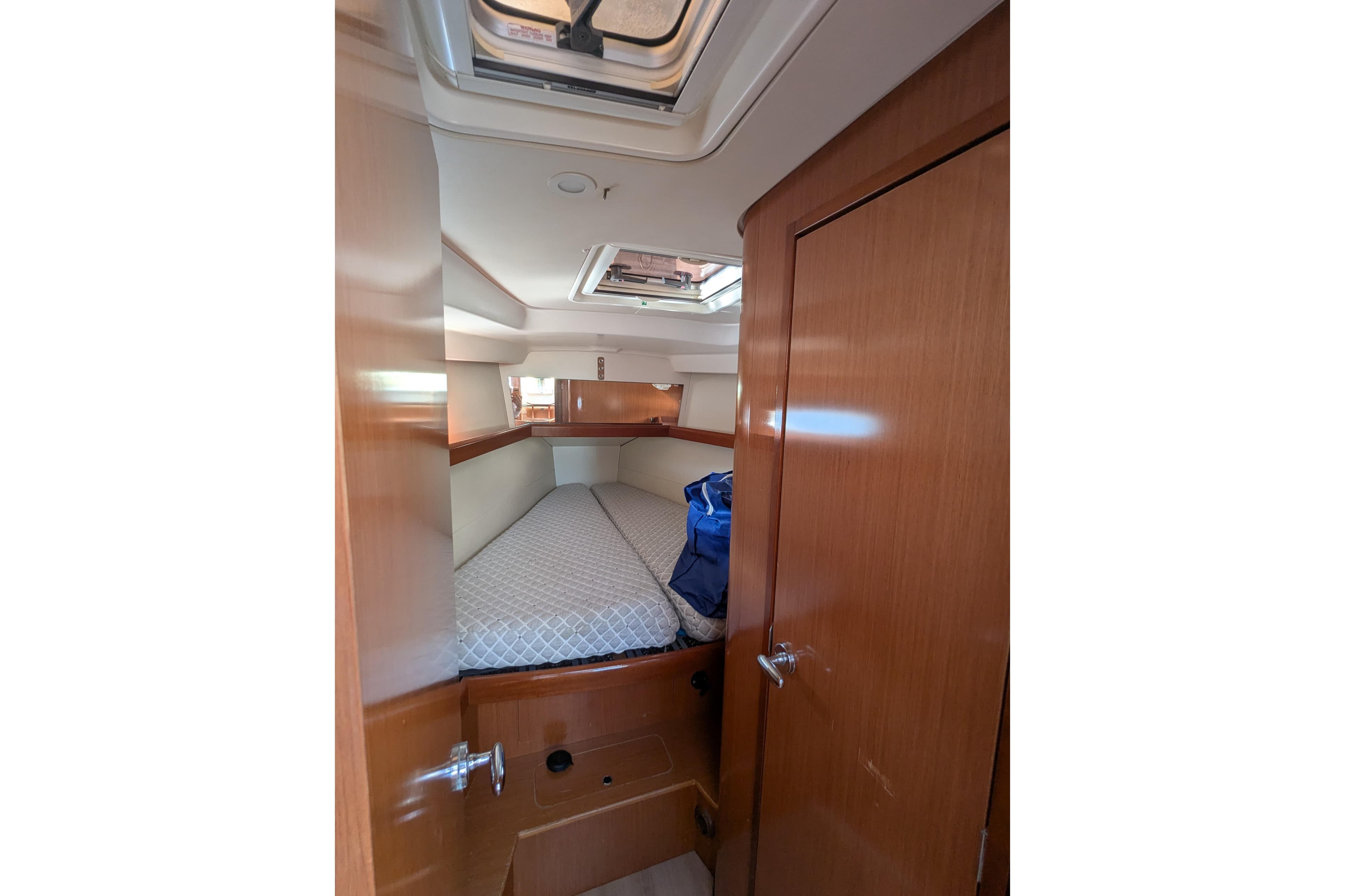 Cozy cabin interior of 2009 Beneteau Oceanis 40 sailboat with bed and wooden finish.
