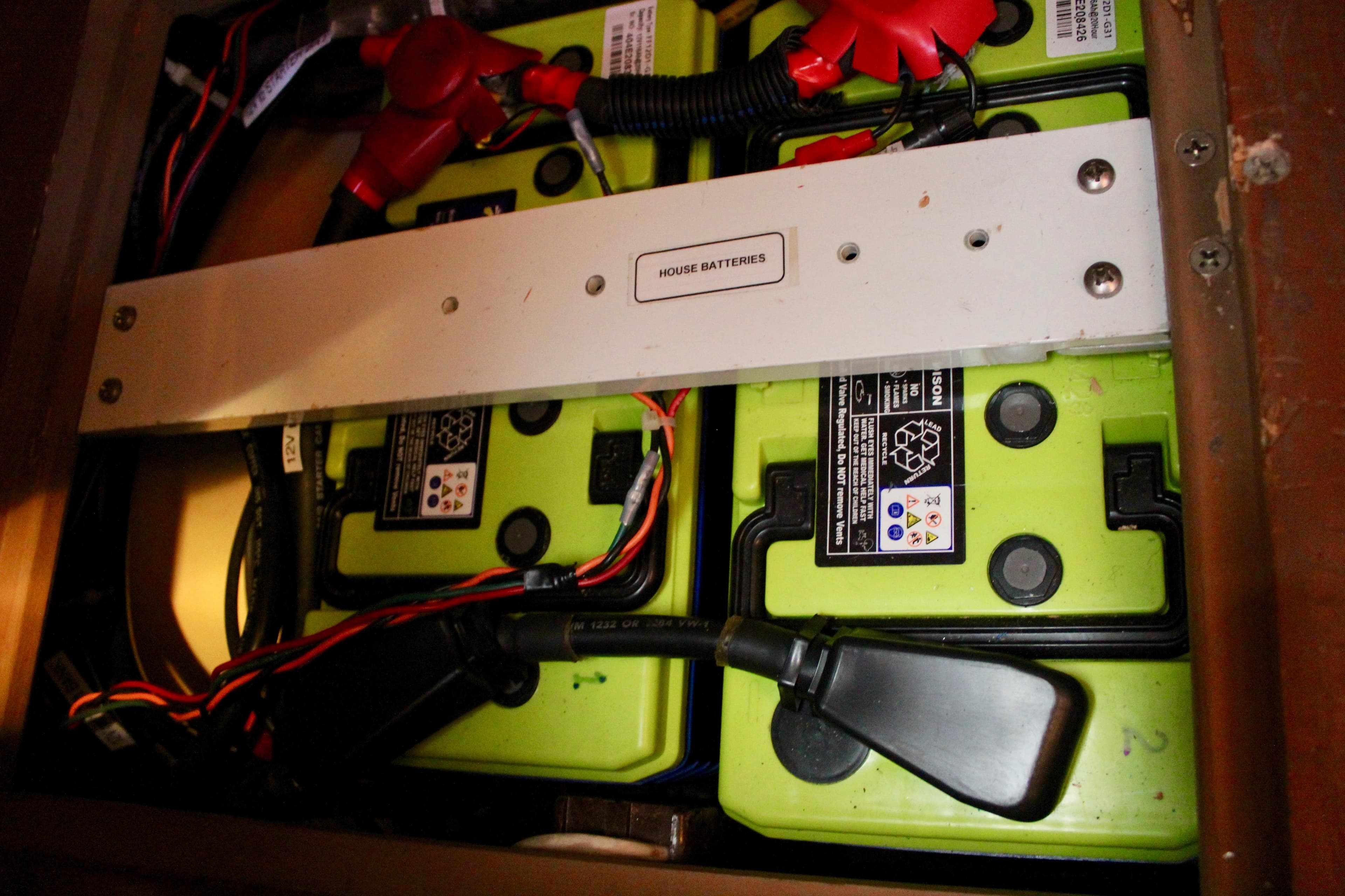 House batteries in a 1997 Valiant 39, featuring green casing and wiring connections.