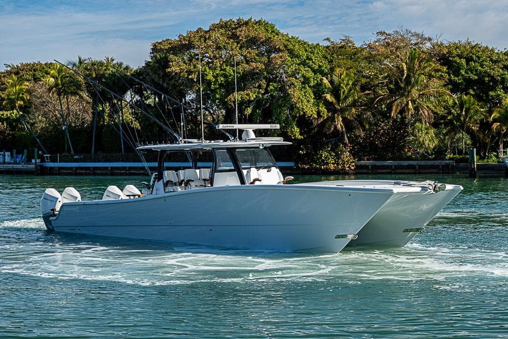 2023 Freeman 47 boat cruising on a scenic waterway with lush greenery.