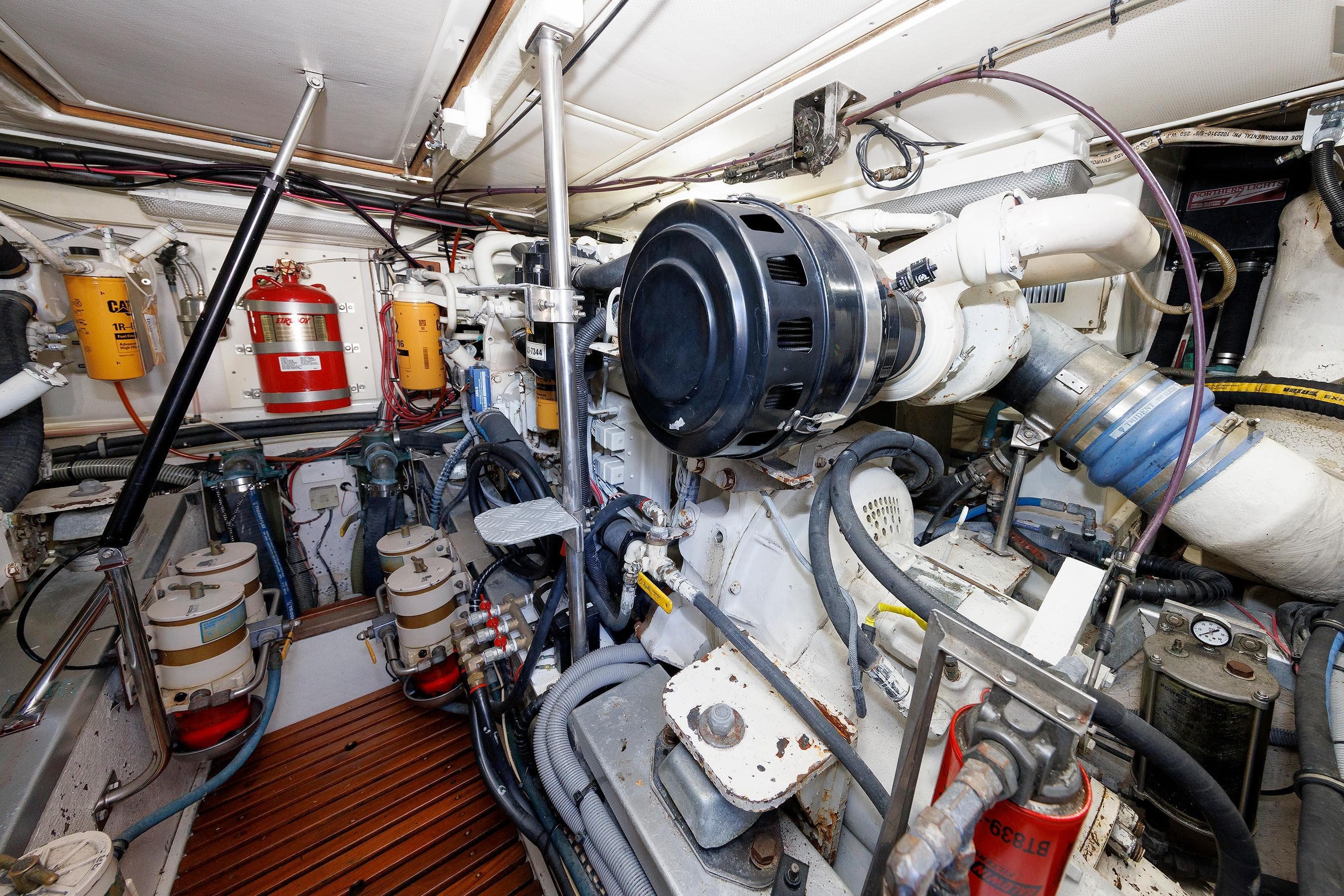 Engine room of a 2000 Eastbay 49 yacht, showcasing complex machinery and equipment.