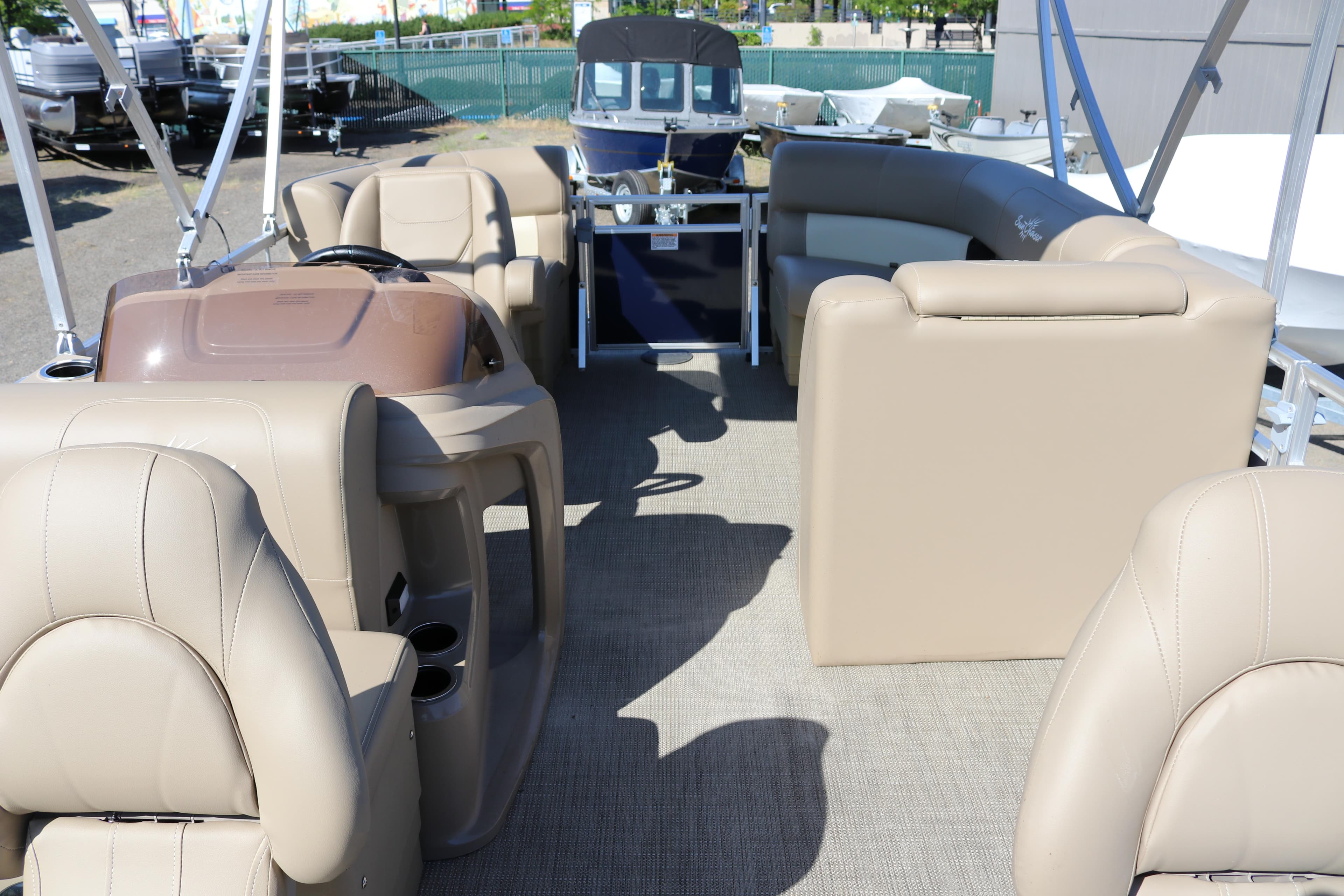 Interior of 2025 Sun Chaser Vista Fish 18 pontoon boat with beige seating.