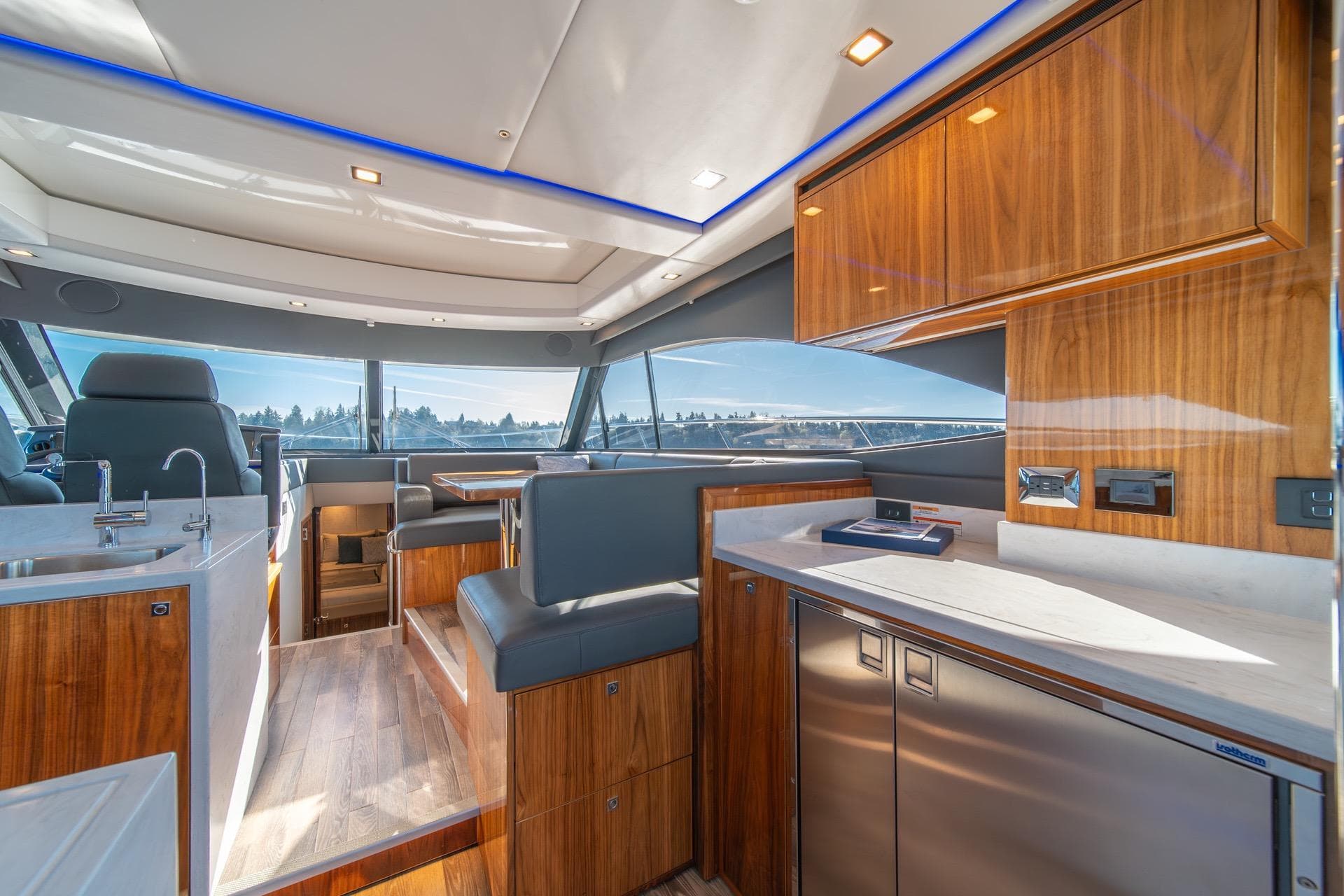 Luxurious interior of 2023 Riviera 4600 Sport Yacht Platinum Edition with modern kitchen and seating.