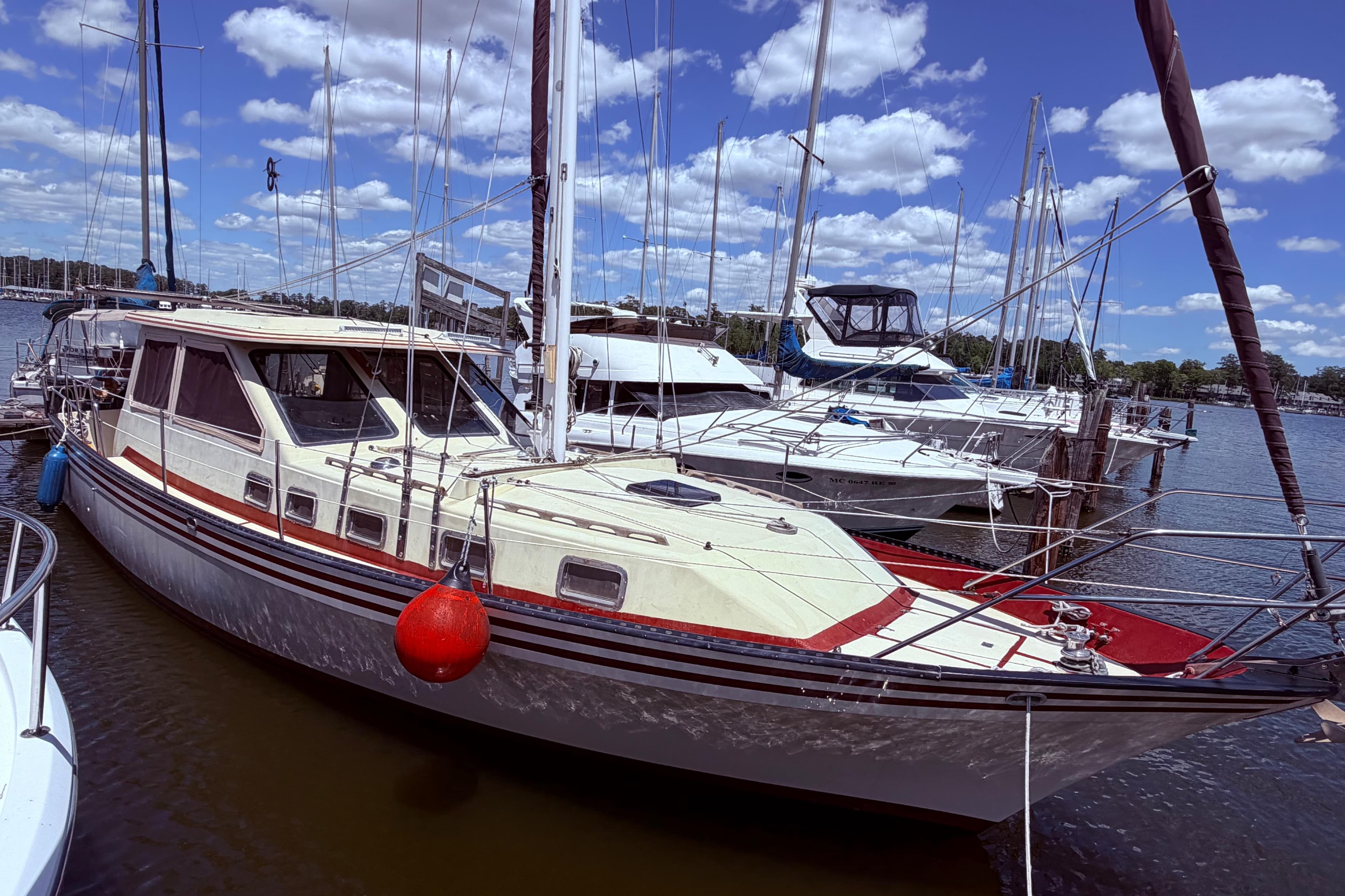 1985 Lancer Yachts 40 Motorsailer docked at marina under blue sky.