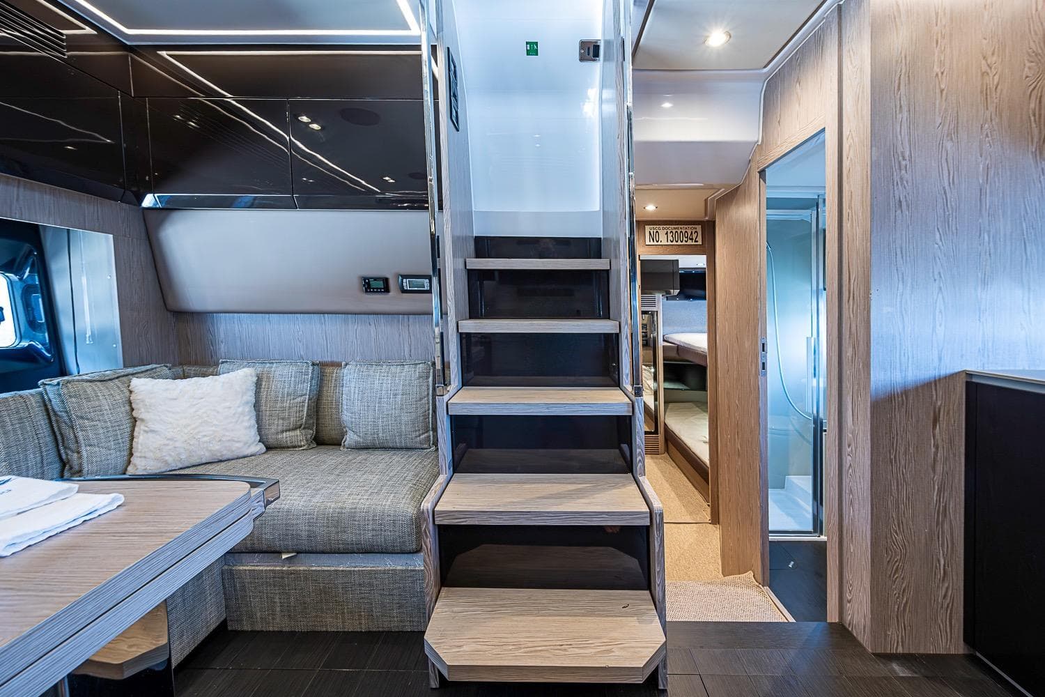 Luxurious interior of 2019 Azimut Atlantis 51 yacht with modern staircase and cozy seating area.