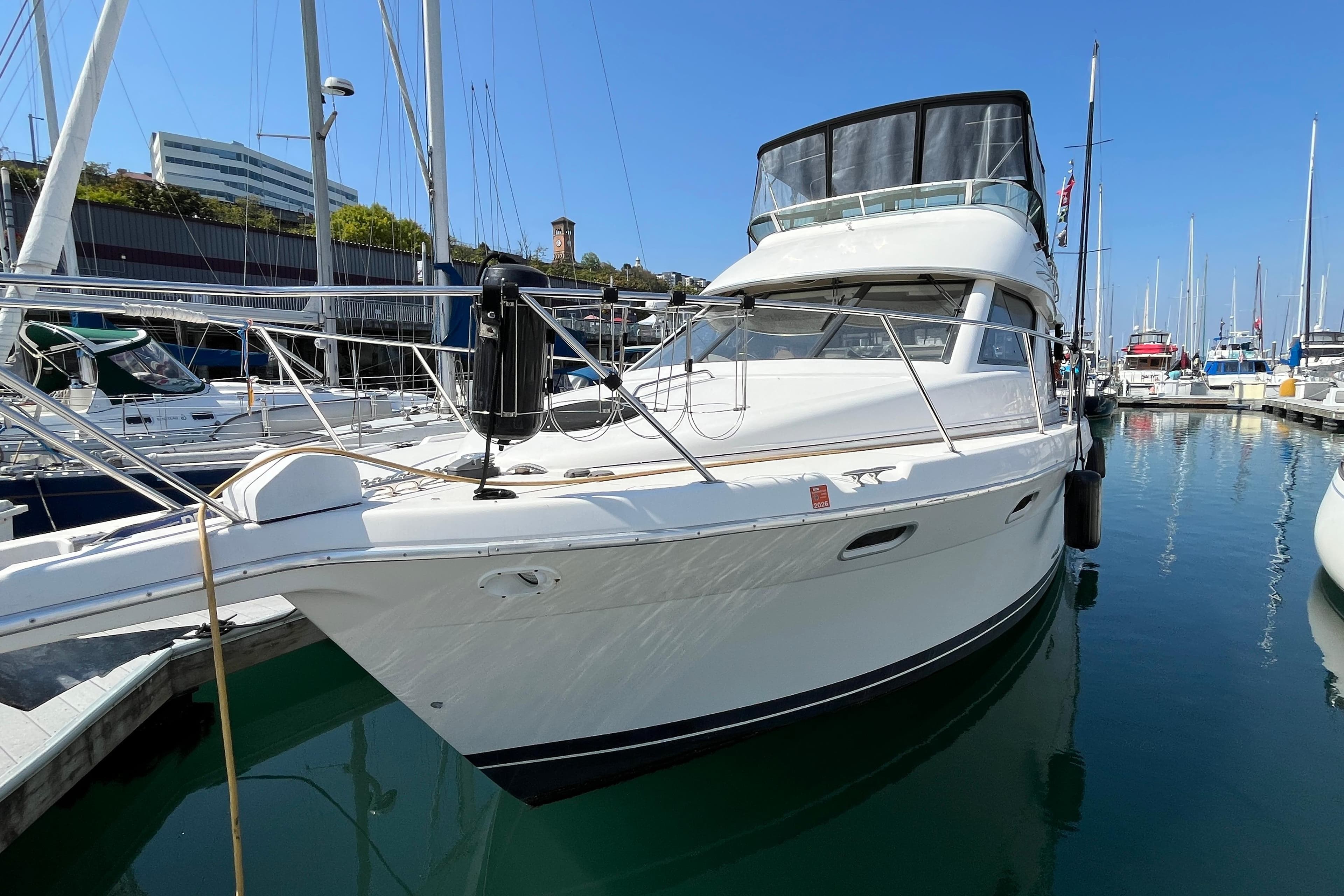 1996 Bayliner 3788 Command Bridge Motoryacht docked in a marina under clear blue skies.