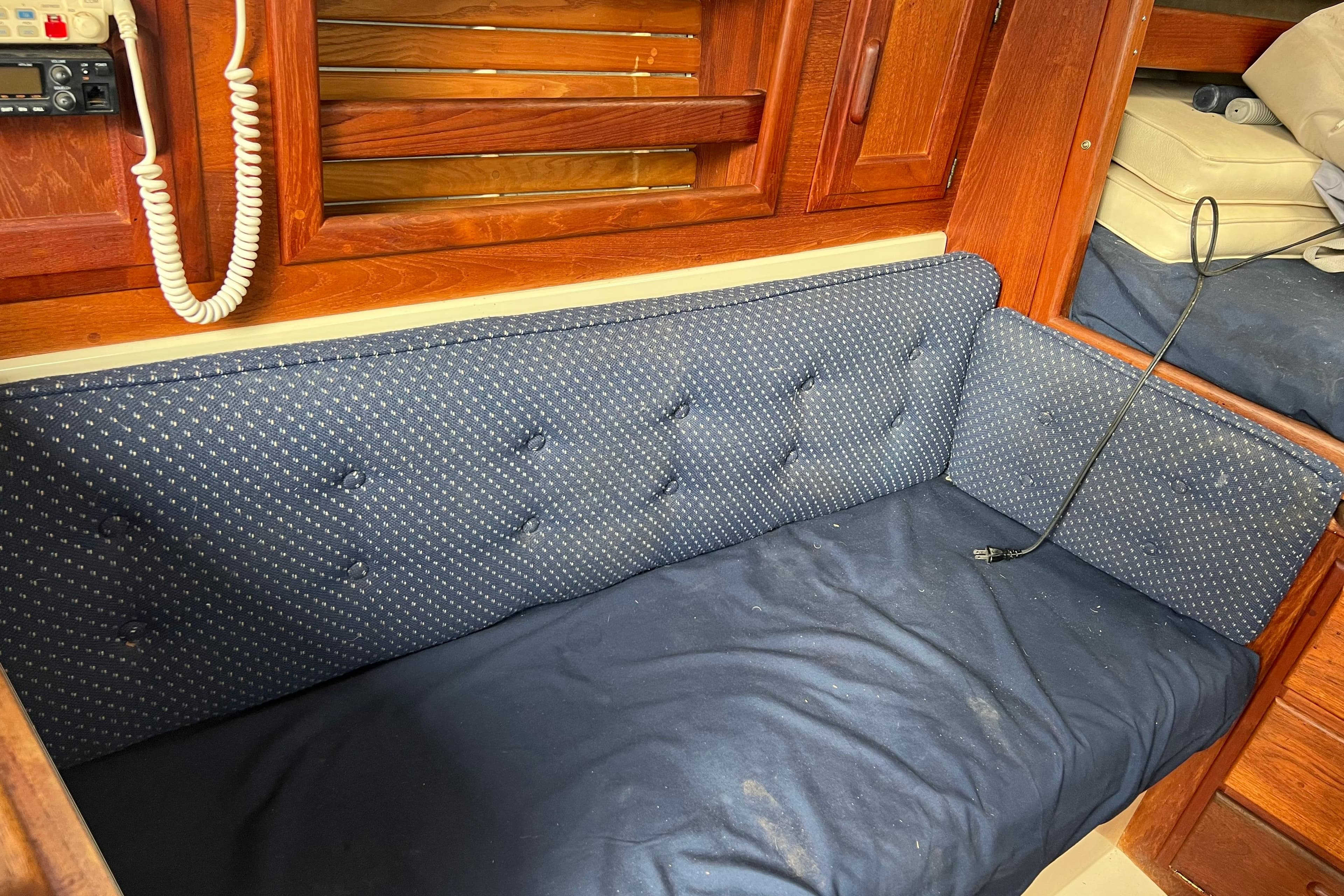 Interior of 1989 Pacific Seacraft Dana 24 sailboat with blue cushioned seating.