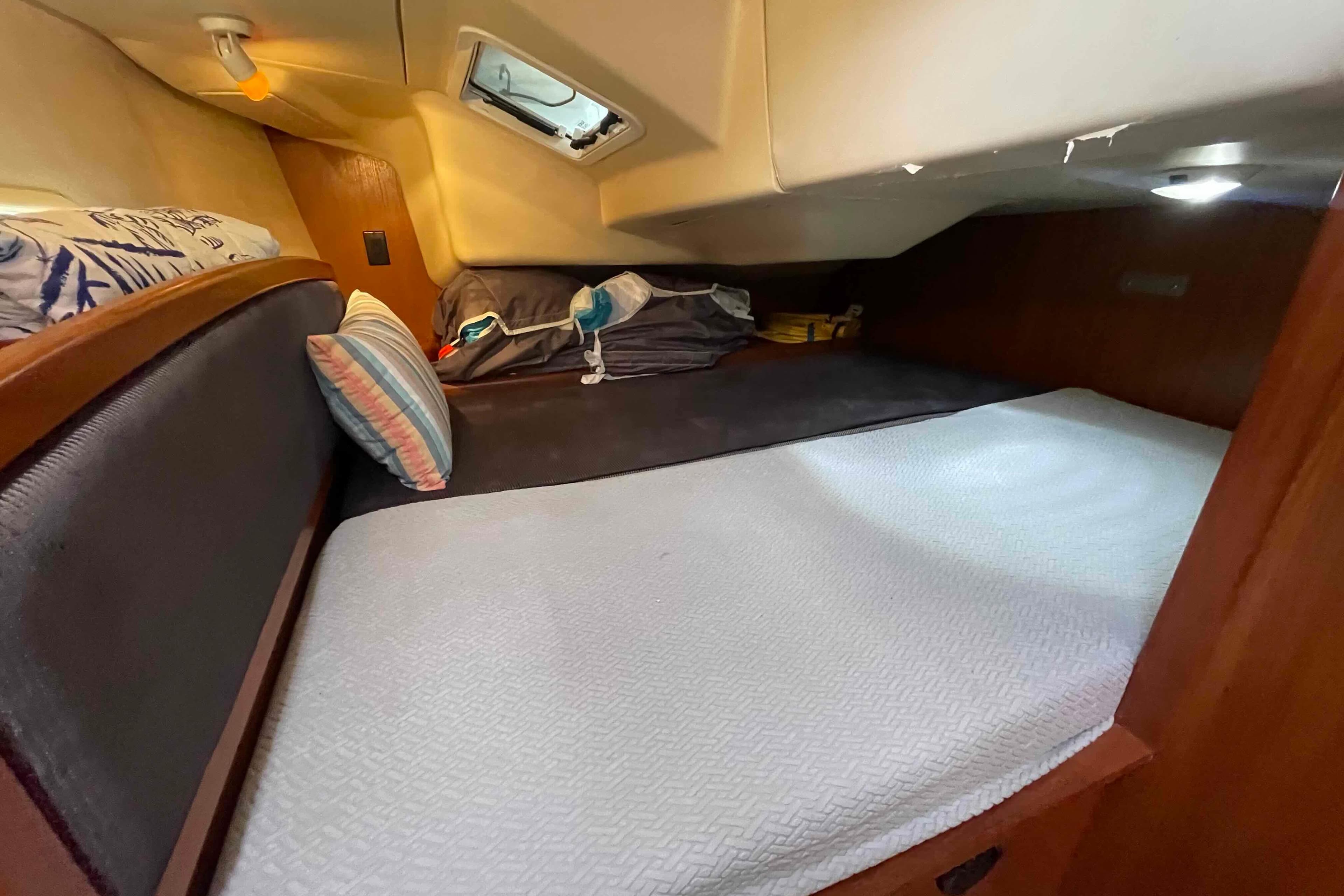 Cozy cabin interior of a 2004 Hunter 36 sailboat with bedding and storage.