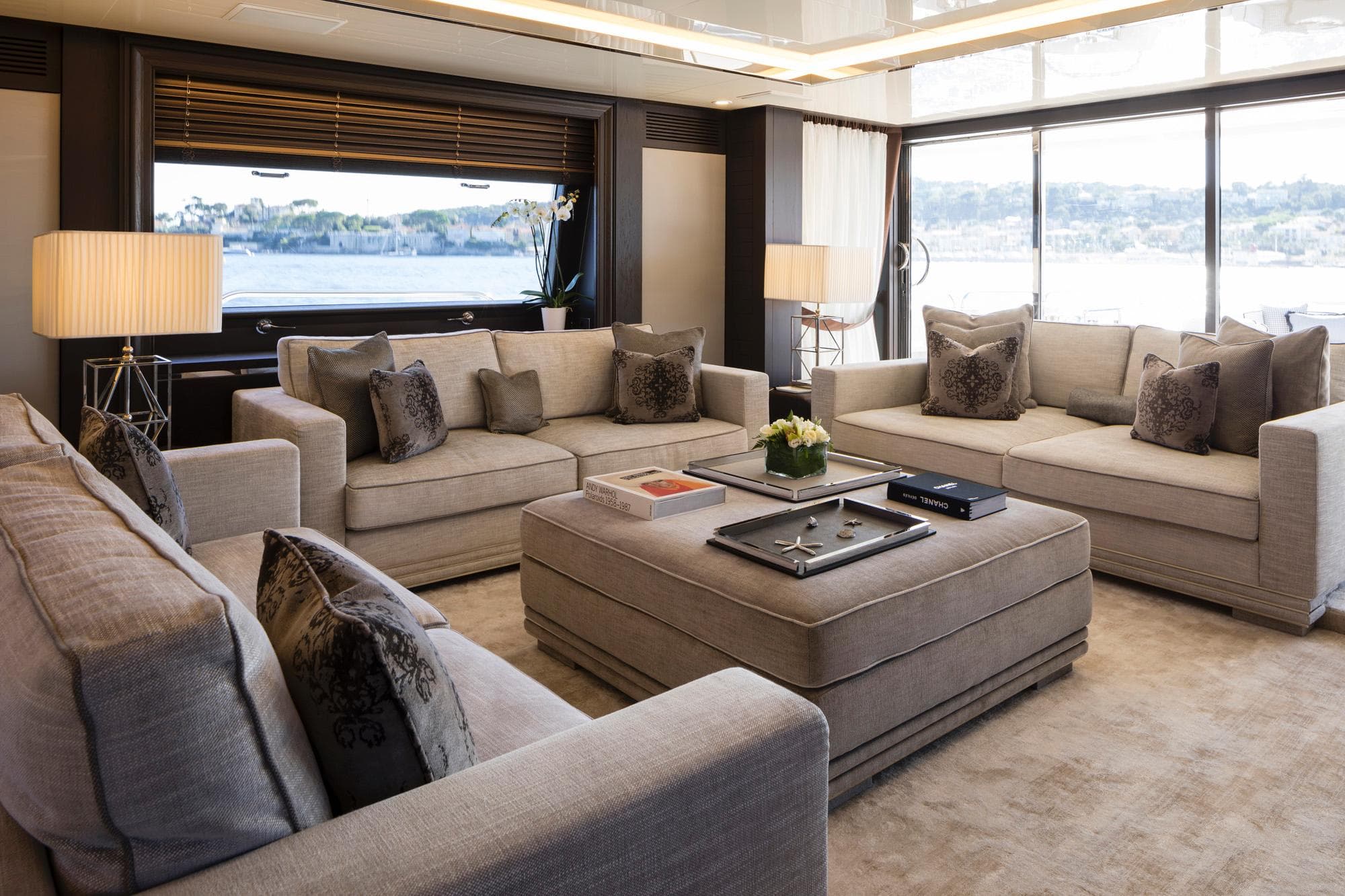 Luxurious yacht interior with beige sofas, large windows, and elegant decor, Feadship Custom 1982.