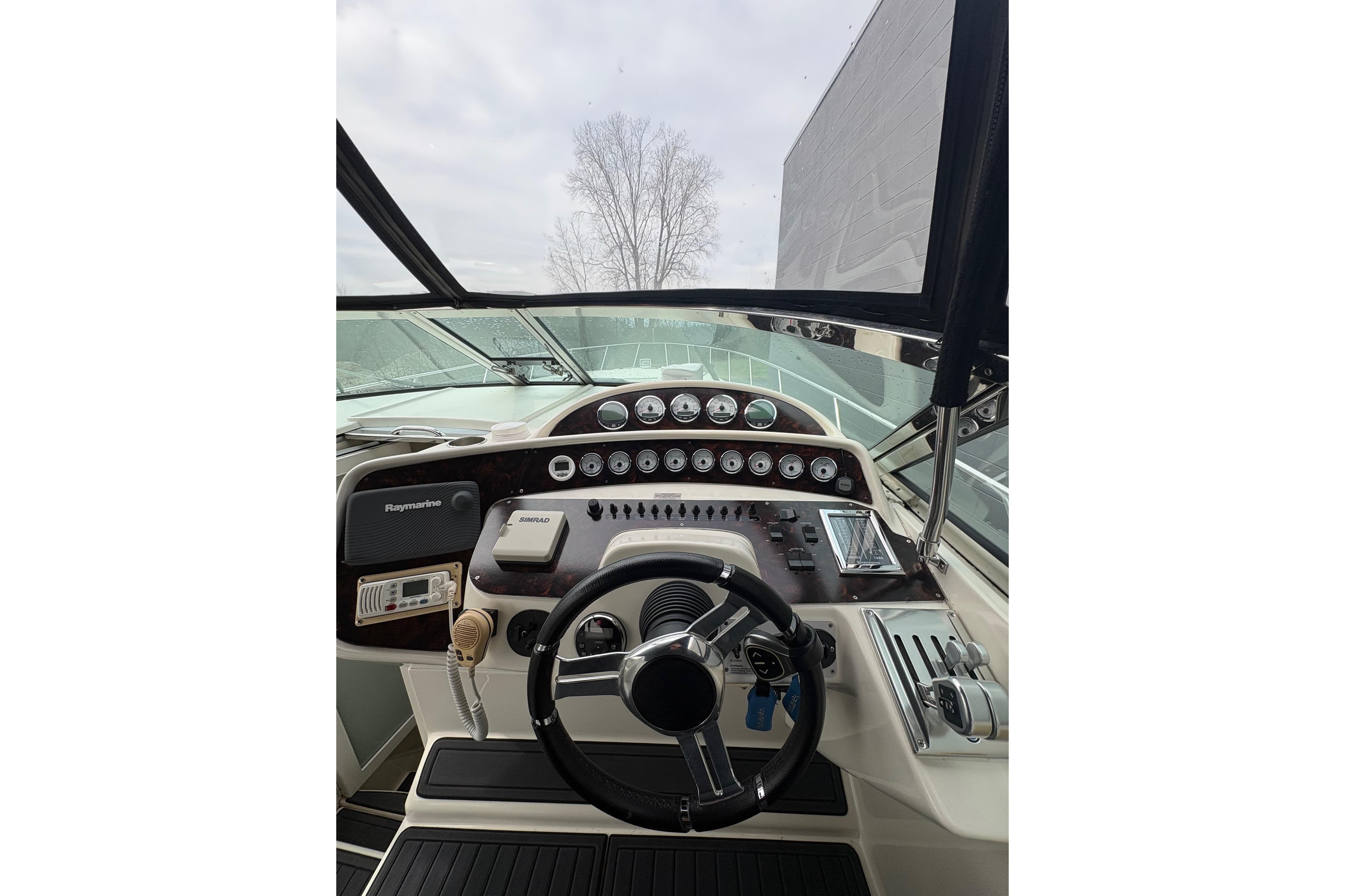 Cockpit view of 1999 Wellcraft 45 Excalibur boat with steering wheel and control panel.
