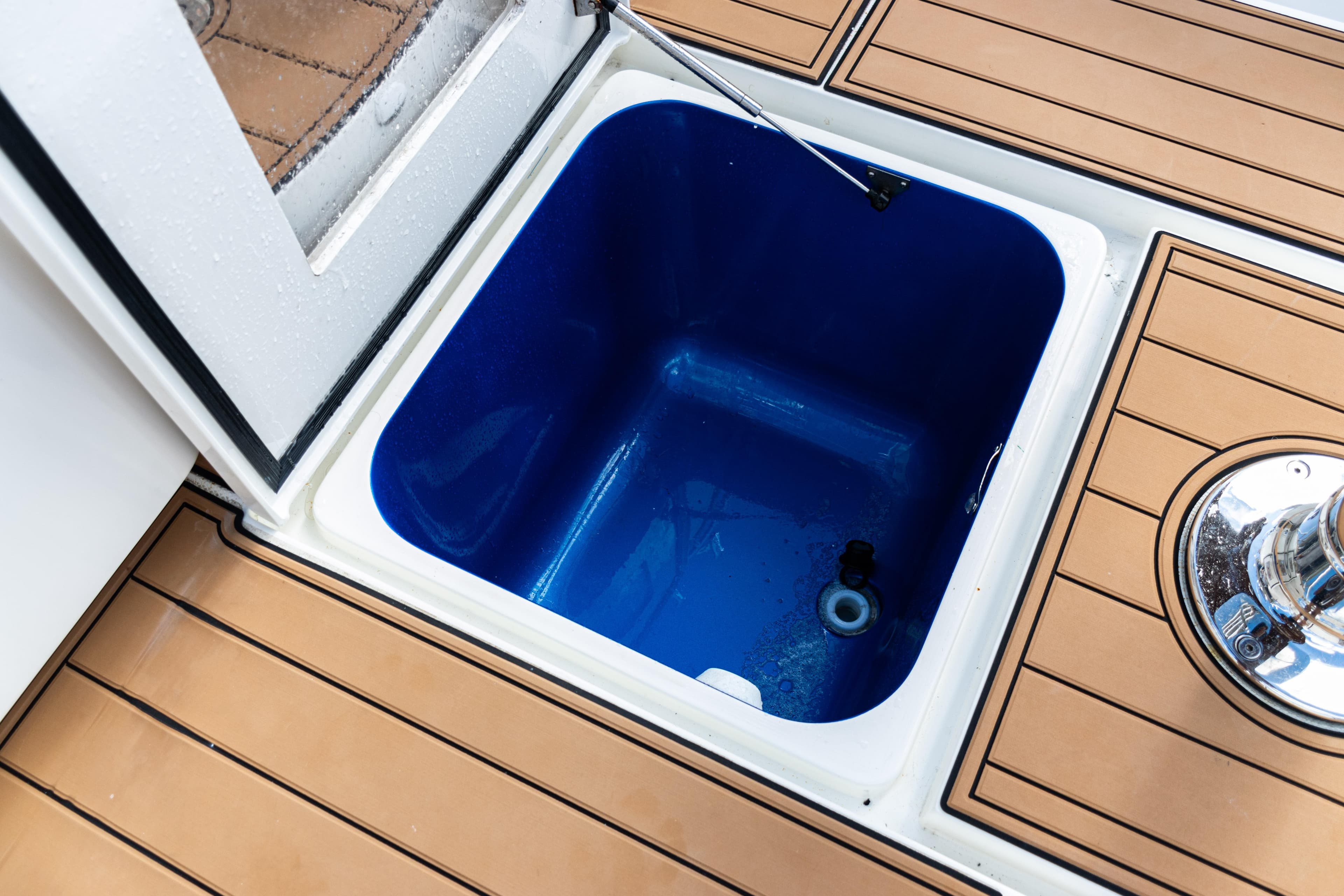 Open storage compartment on 2016 SeaVee 430 boat with teak flooring.