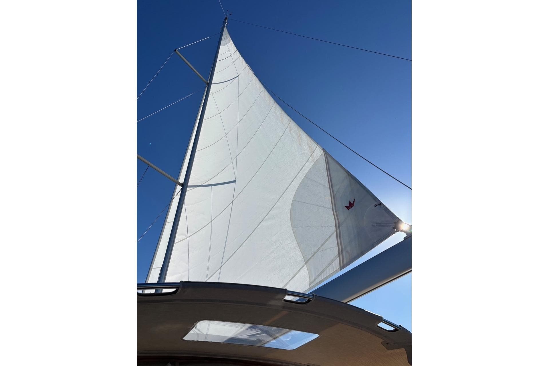 Sail of 2022 Dufour 390 yacht against clear blue sky.