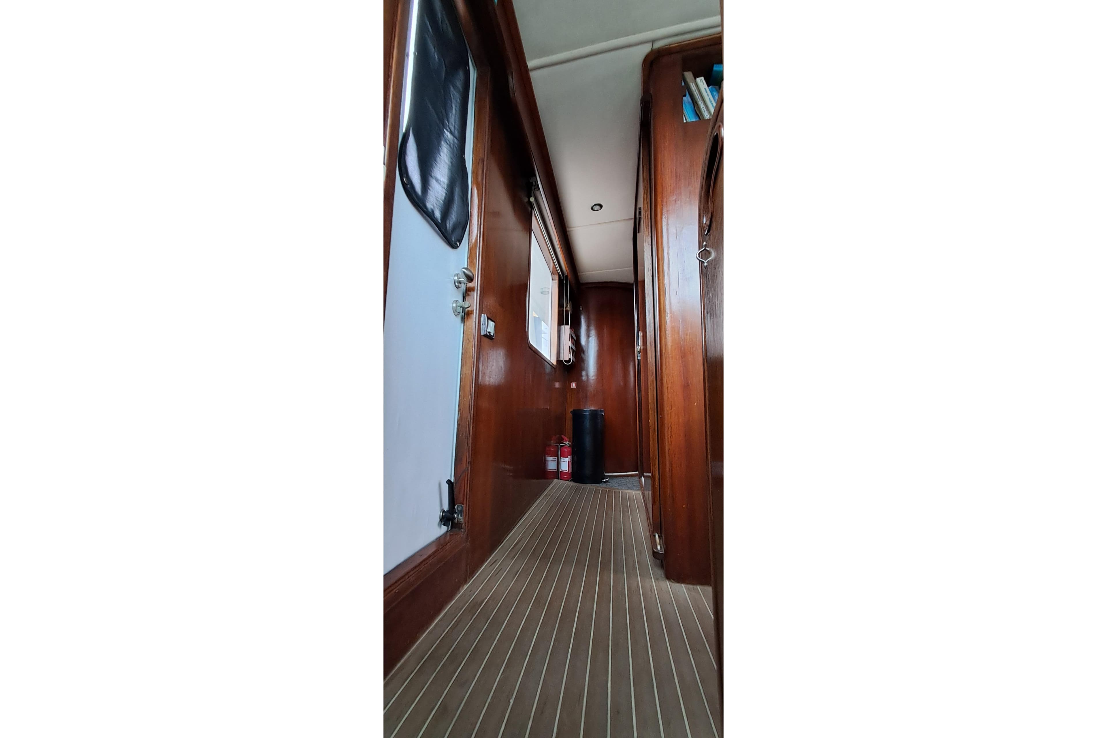 Interior hallway of 2003 DeFever 57 POC yacht with wooden paneling and flooring.