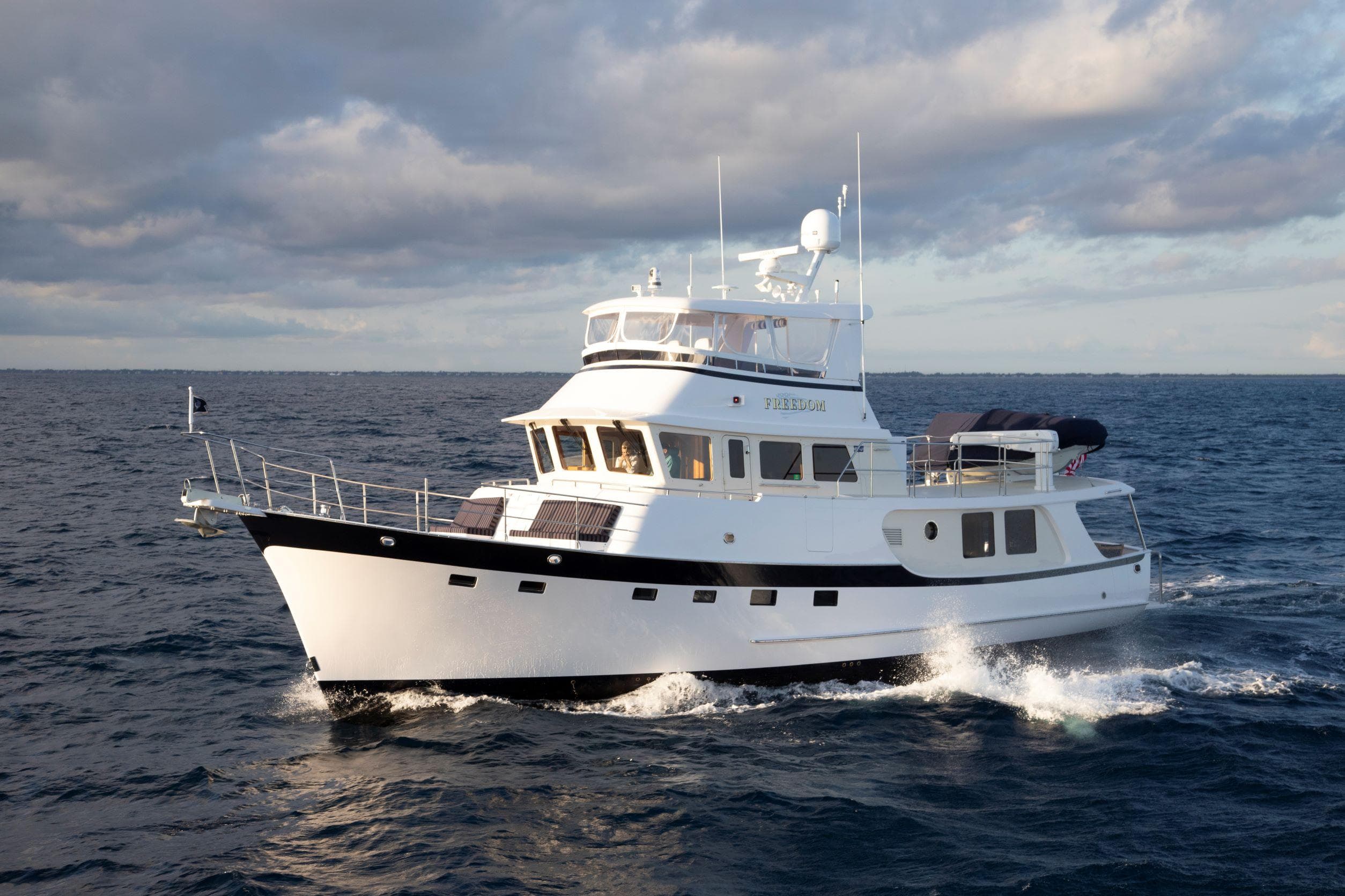 2025 Krogen 58 Extended Bridge yacht cruising on open sea under cloudy skies.