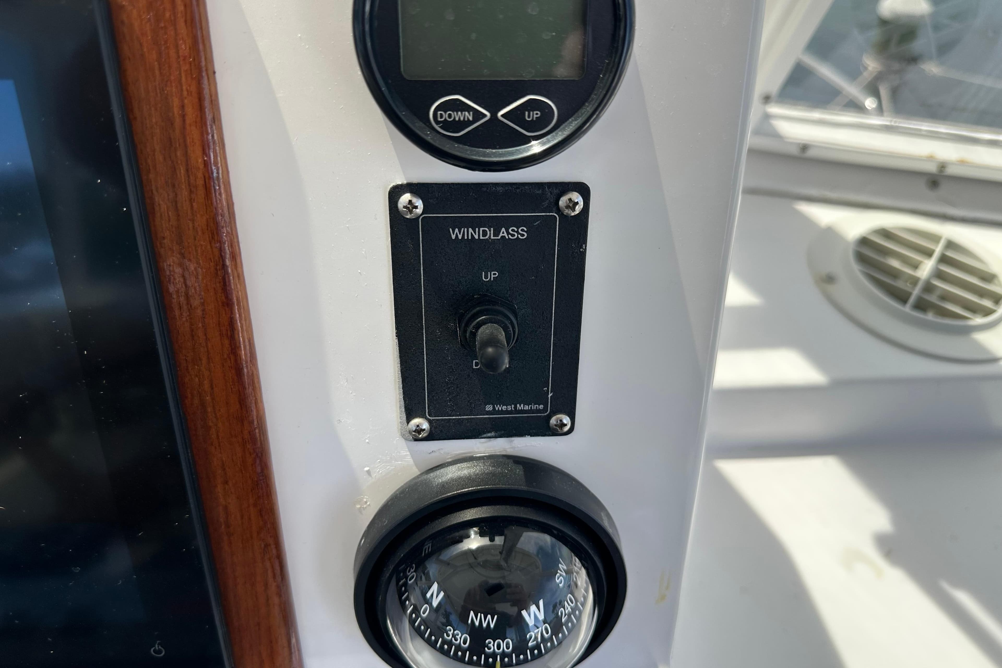 Control panel on a 1987 Kadey-Krogen Manatee 36 boat, featuring windlass and compass.