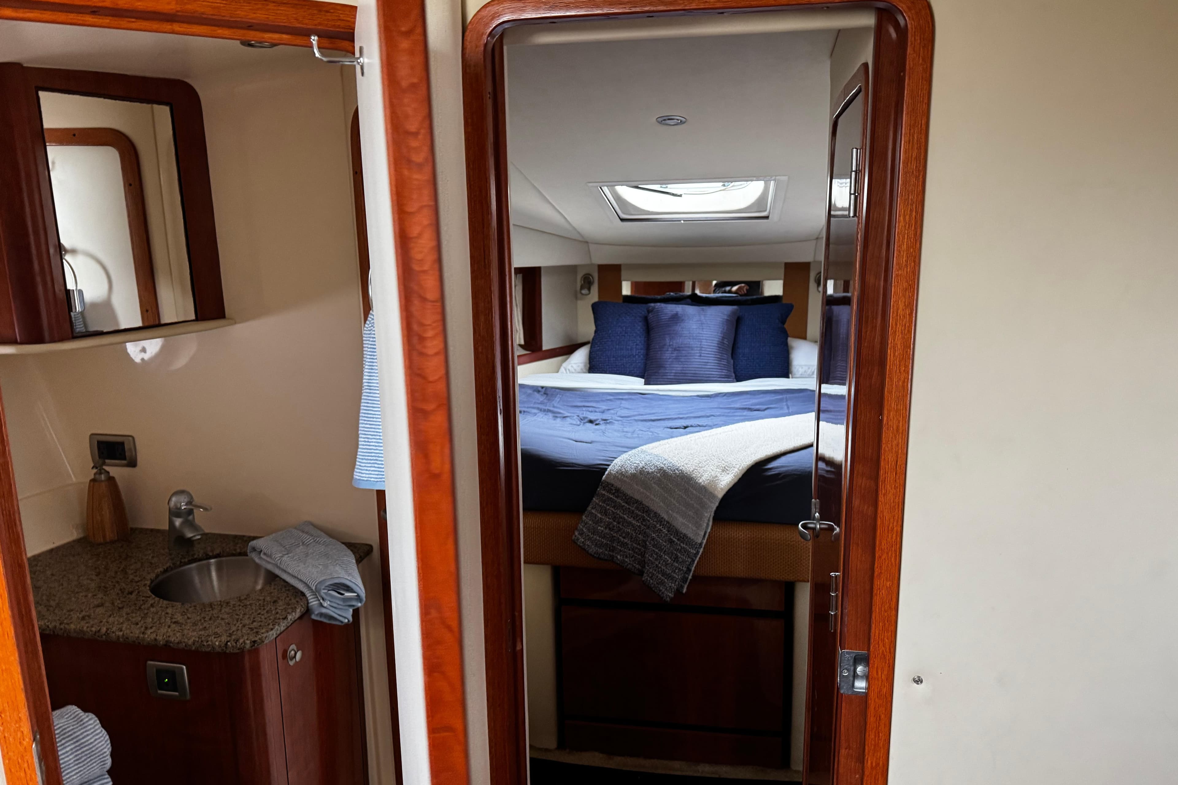 Interior of 2006 Sea Ray 38 Sundancer yacht with cozy bedroom and compact bathroom.