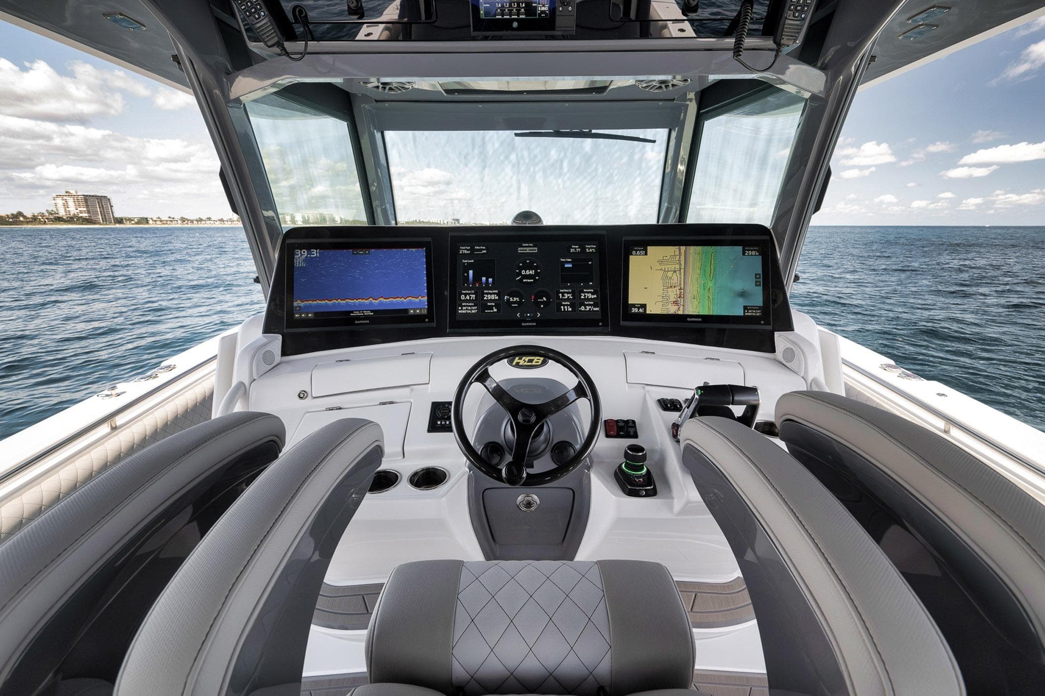Helm of 2025 HCB 53 Suenos boat with advanced navigation displays on open sea.