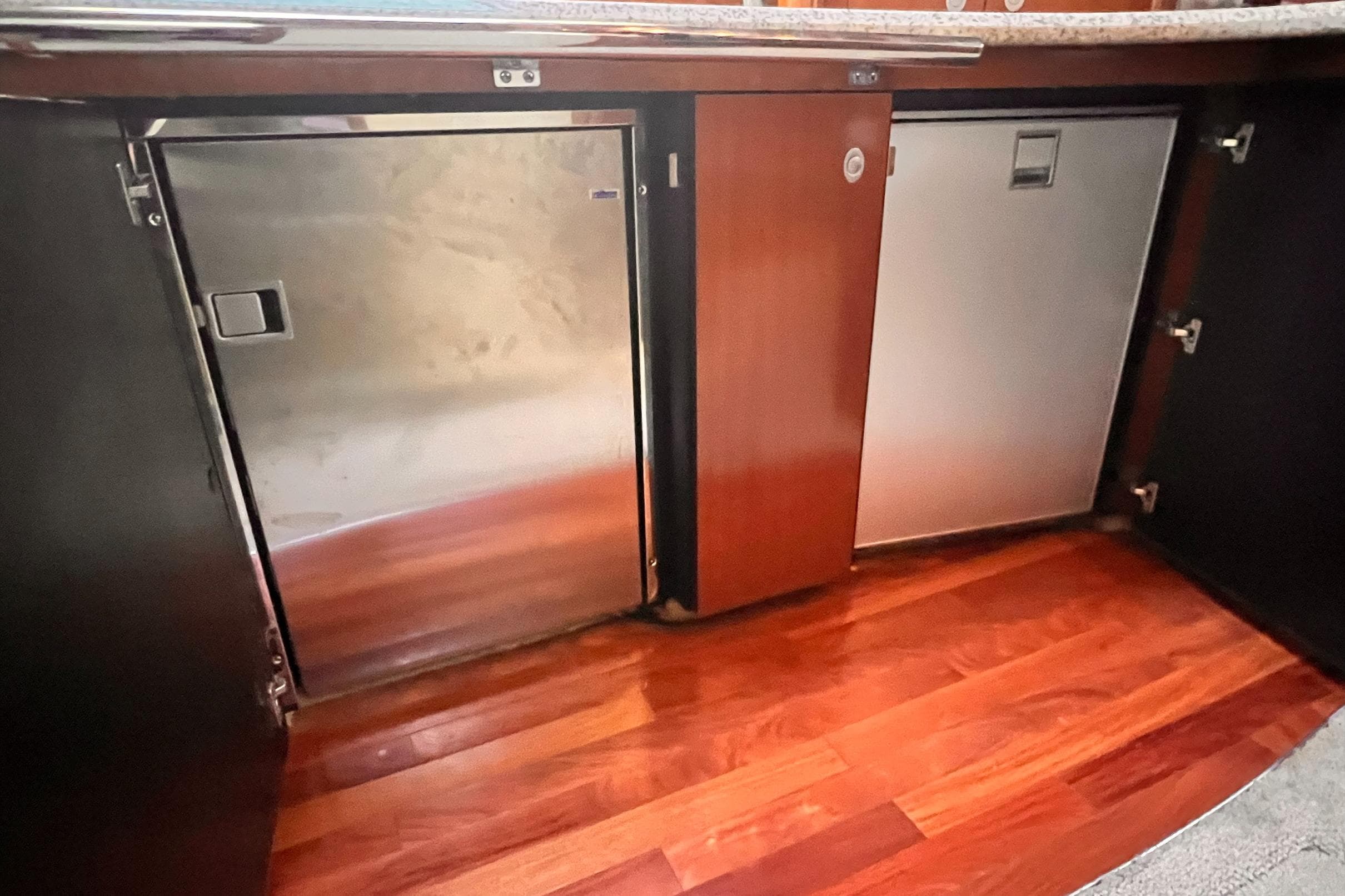 2005 Sea Ray 500 Sundancer interior with stainless steel appliances and wooden flooring.