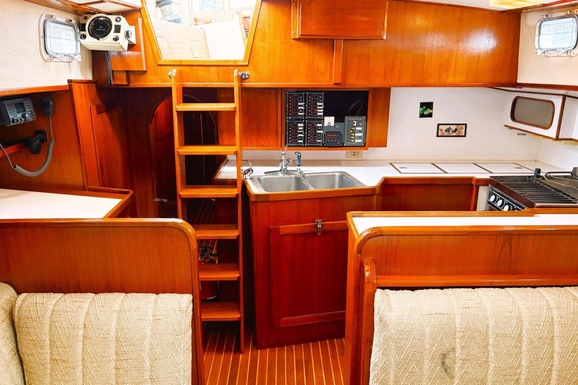 Interior of a 1980 Discovery 42 yacht with wooden cabinetry and compact kitchen.