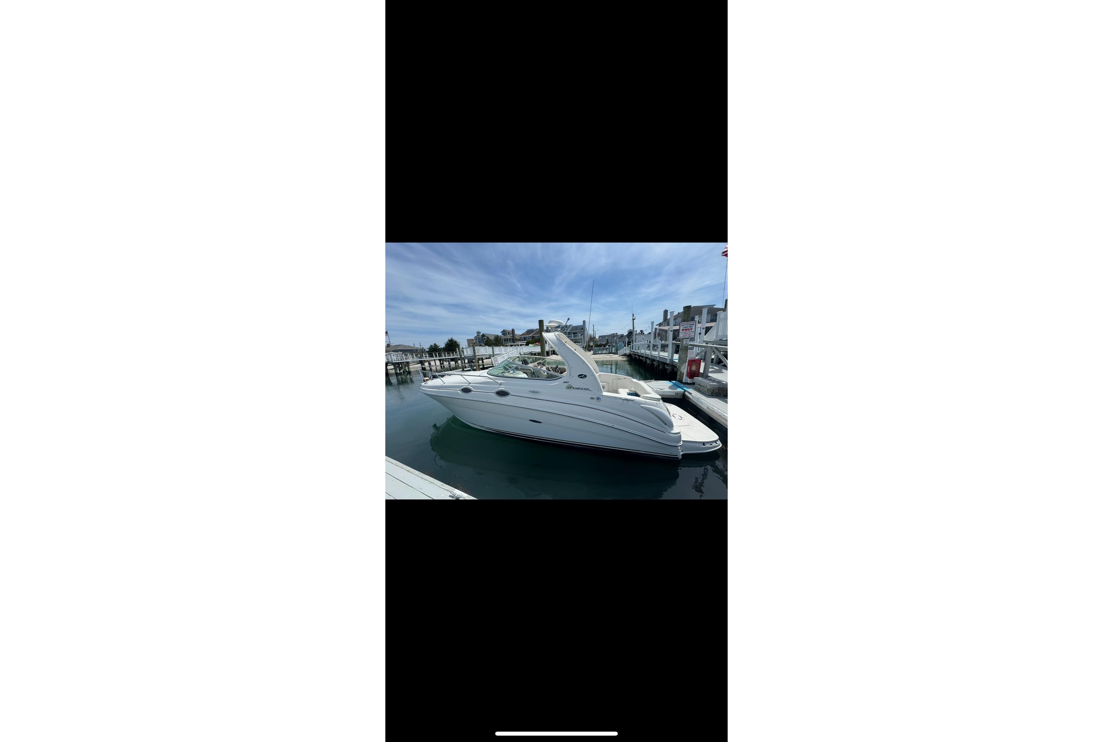 2002 Sea Ray Sundancer 280 docked at a marina under a clear blue sky.
