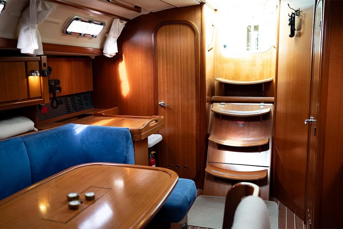 Interior of 2006 Dufour 385 sailboat with wooden finish and blue seating.