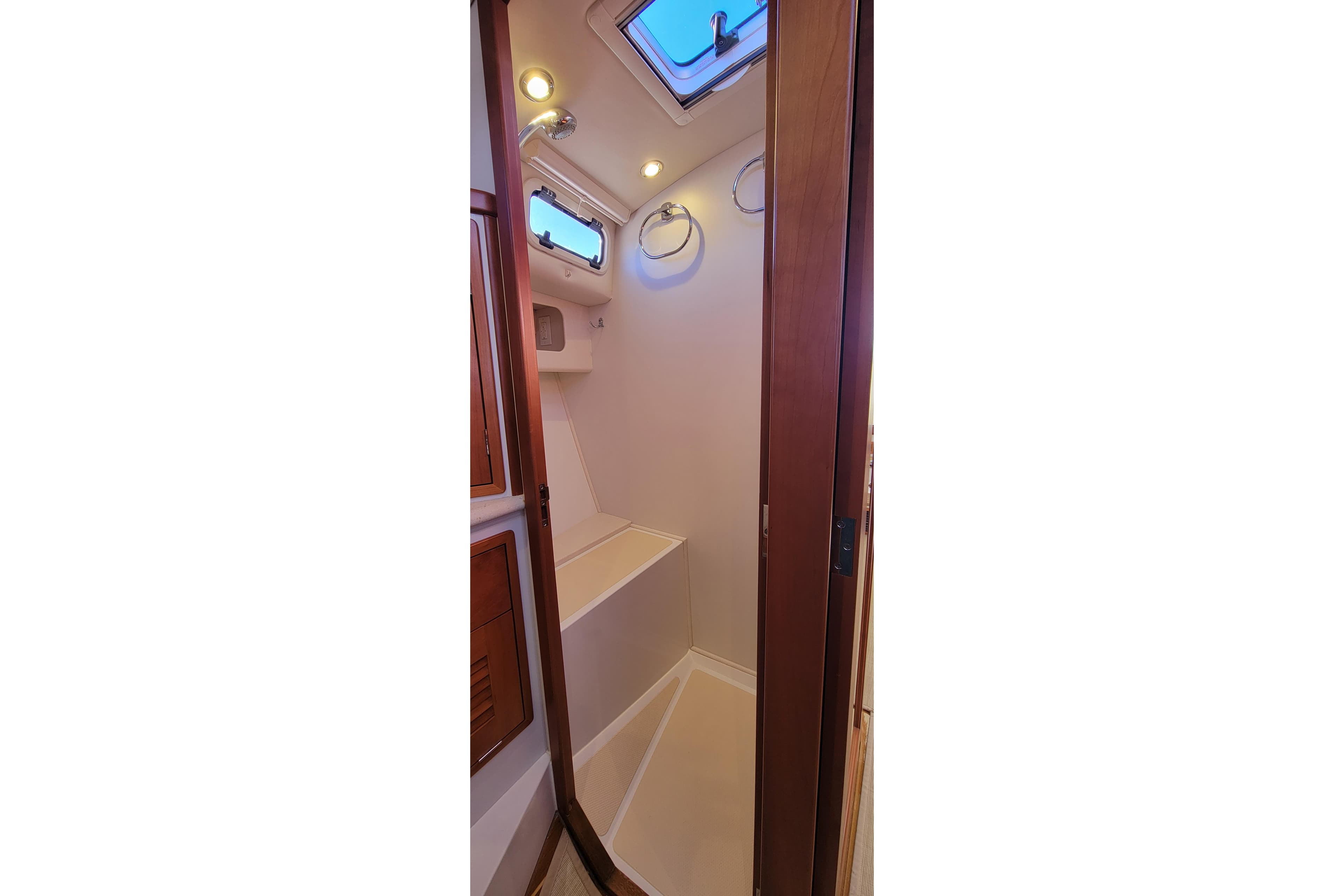 2017 MJM 40z Downeast yacht interior shower with wooden accents and overhead lighting.
