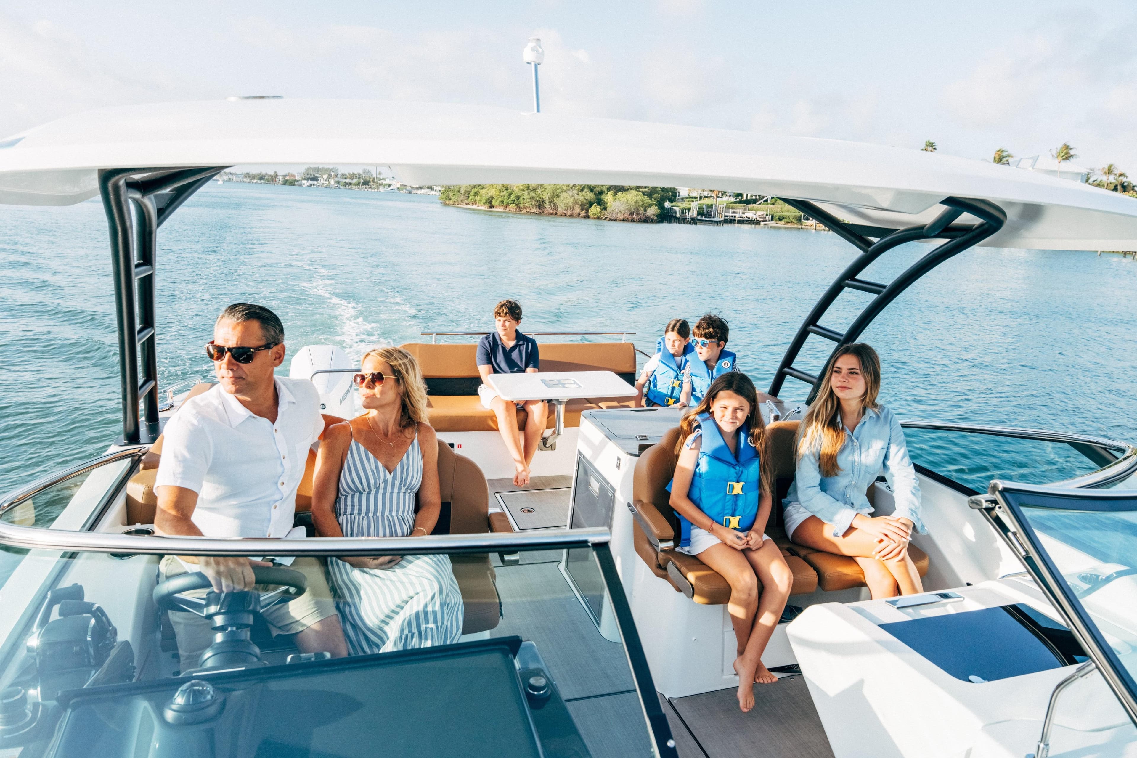 Family enjoying a sunny day on a 2026 Jeanneau TH33 boat.
