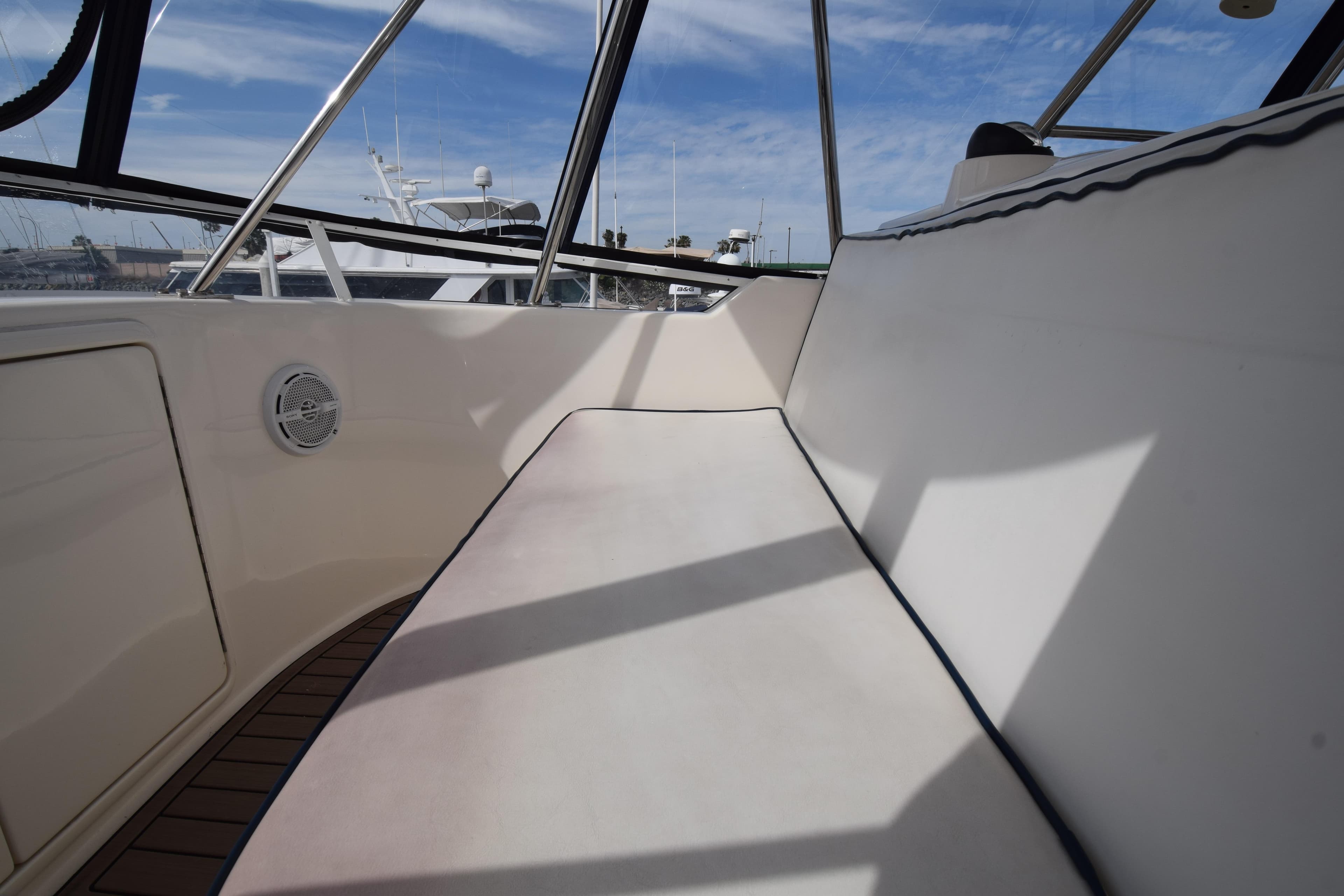 2005 Riviera 33 Open Flybridge interior with cushioned seating and clear windows.