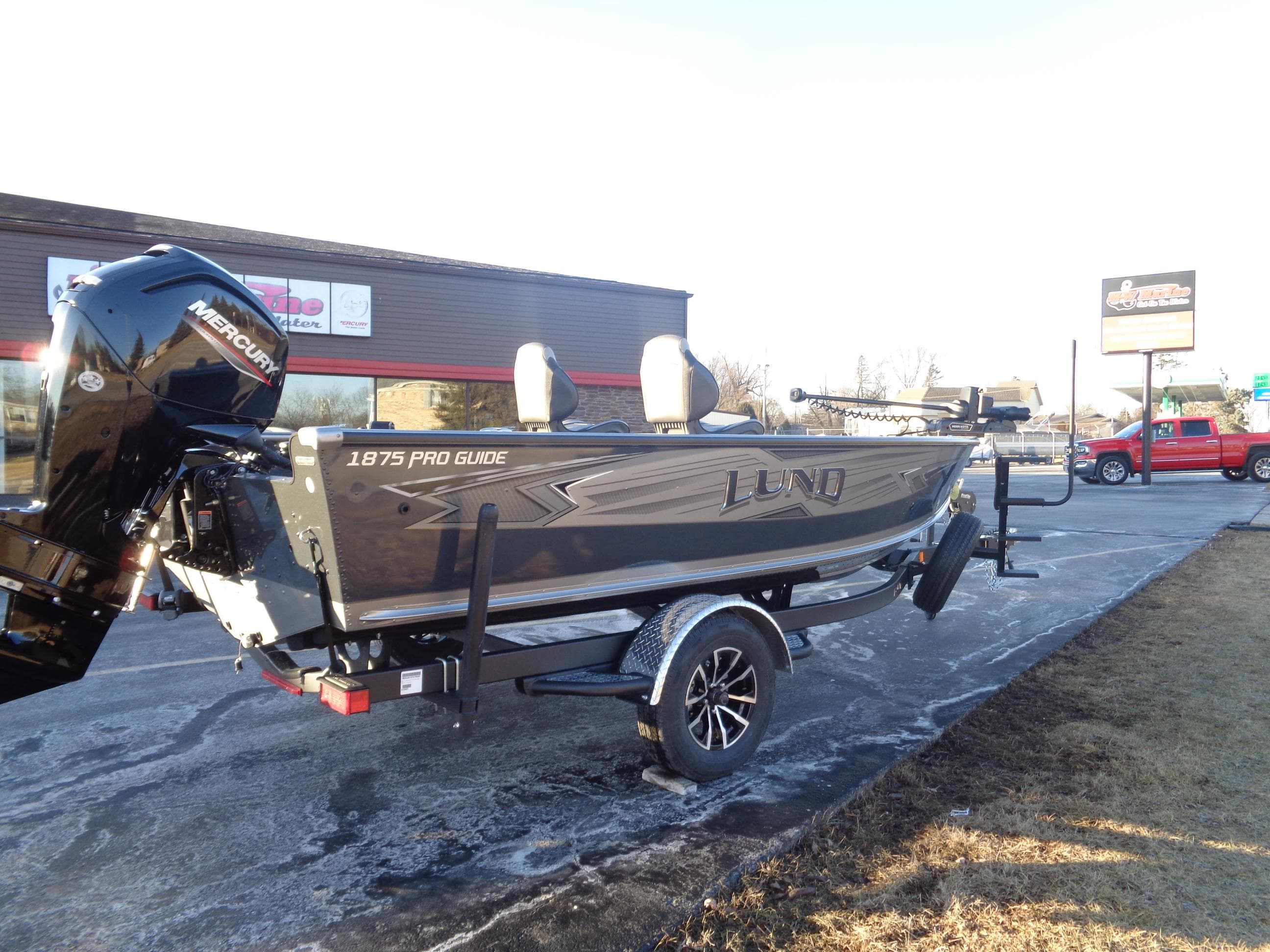 2025 Lund 1875 Pro Guide boat on trailer, parked outdoors.