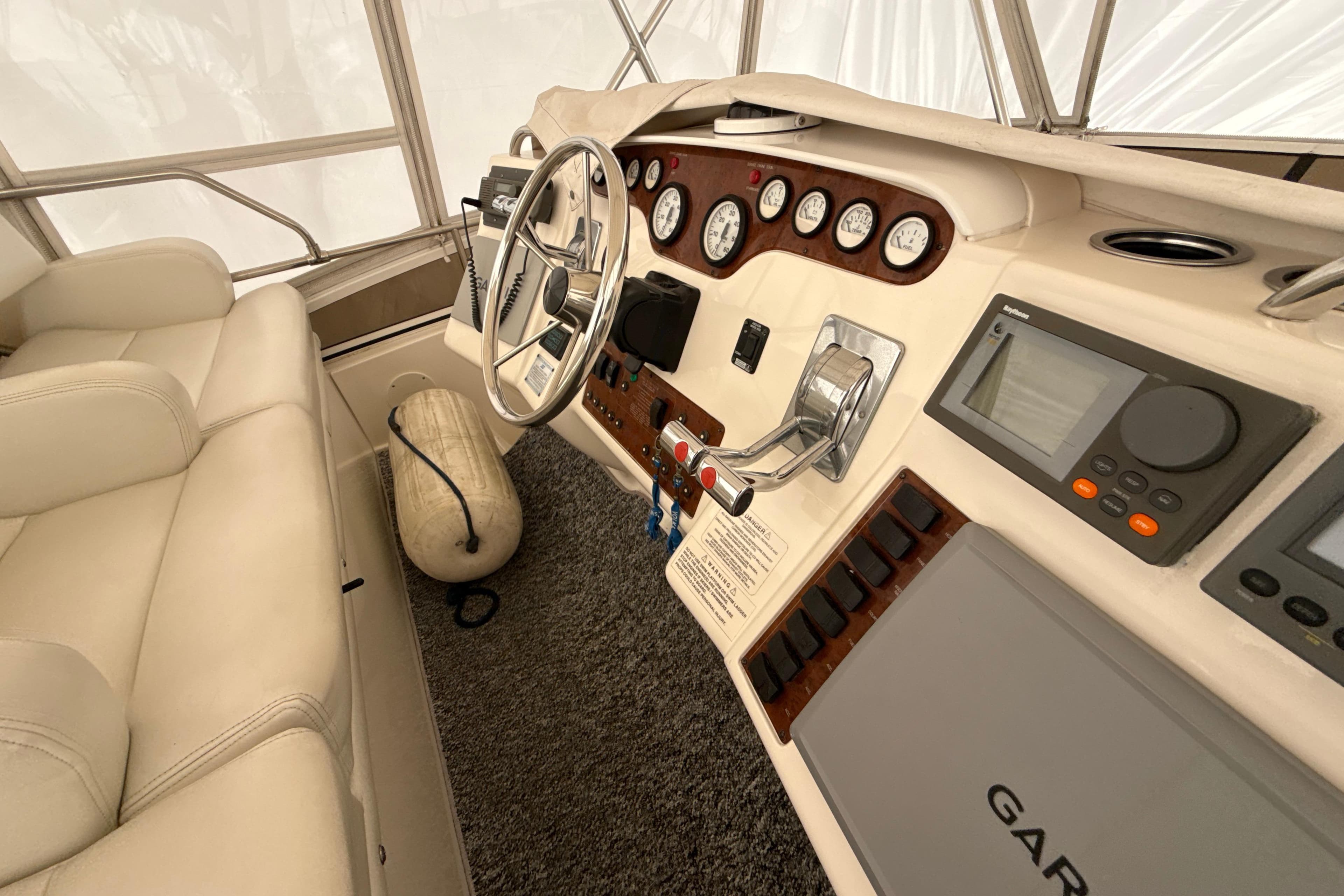 Interior helm of 1999 Silverton 422 Motor Yacht with navigation instruments and steering wheel.