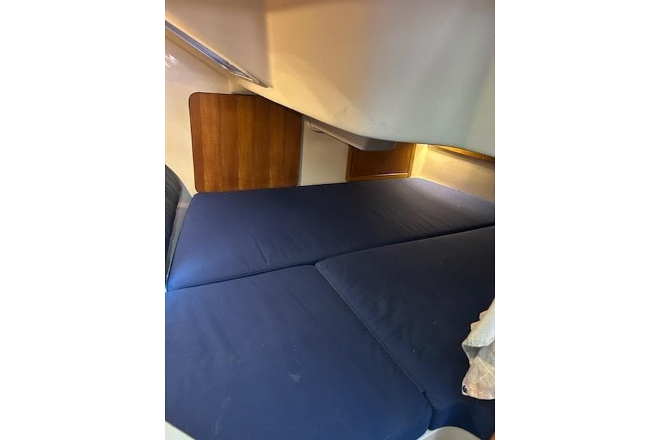 Interior cabin of a 2004 Catalina 310 sailboat with blue cushions.
