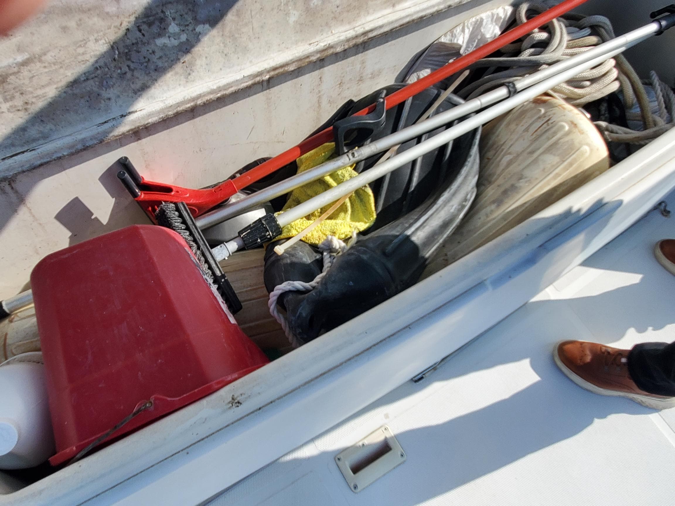 Storage compartment on a 2000 Carver 356 Aft Cabin Motor Yacht with cleaning tools and ropes.
