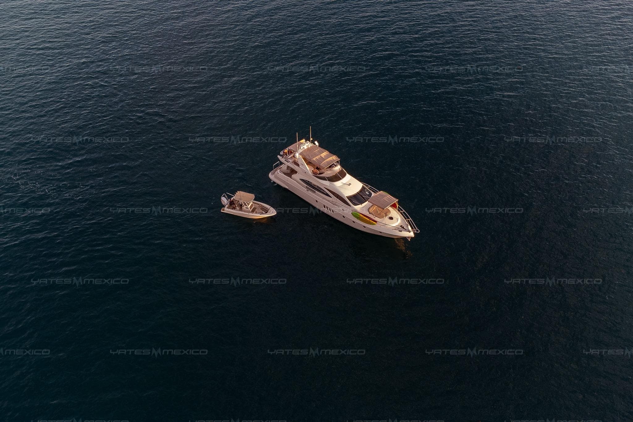 Aerial view of 2004 Azimut 68 Plus yacht with a small boat on open water.
