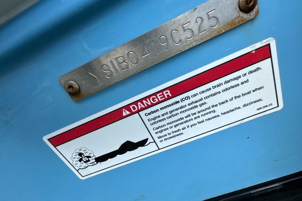 Warning label on 2025 Sailfish 245 DC boat about carbon monoxide dangers.